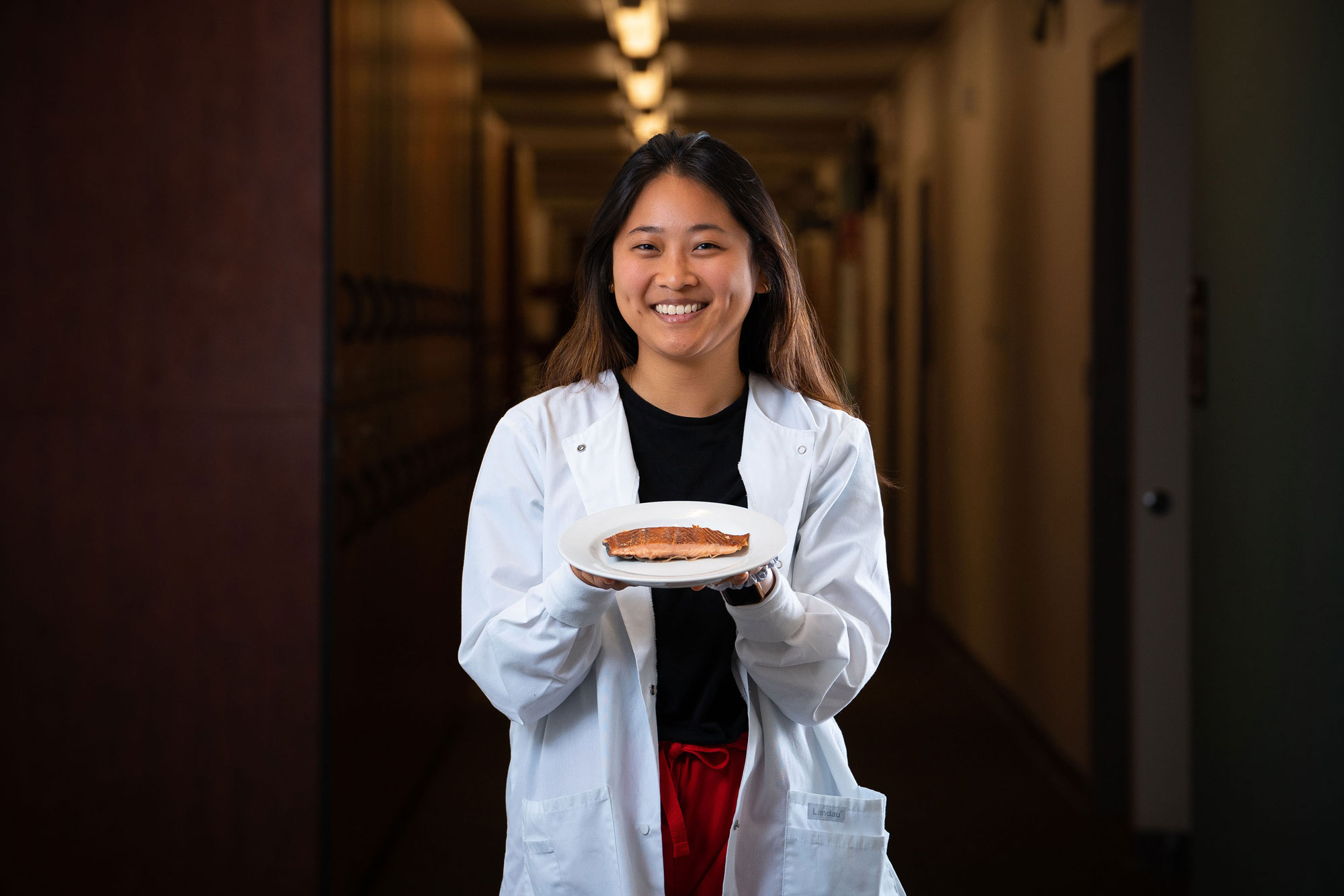 nursing student holding a plate with a salmon filet
