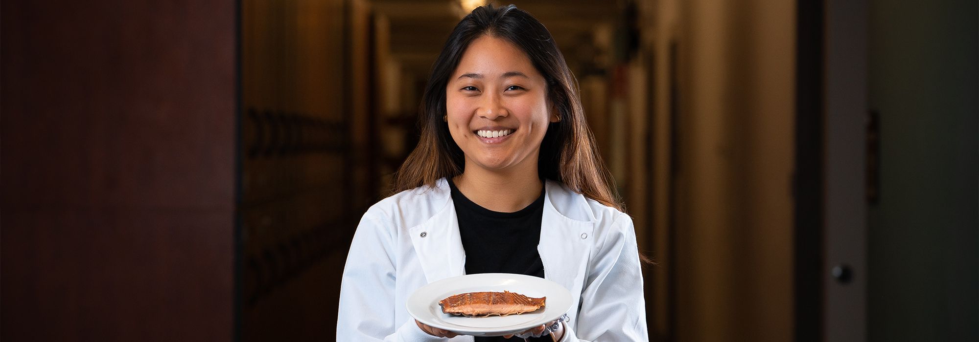 Carolyn Zhang holding a plate of salmon