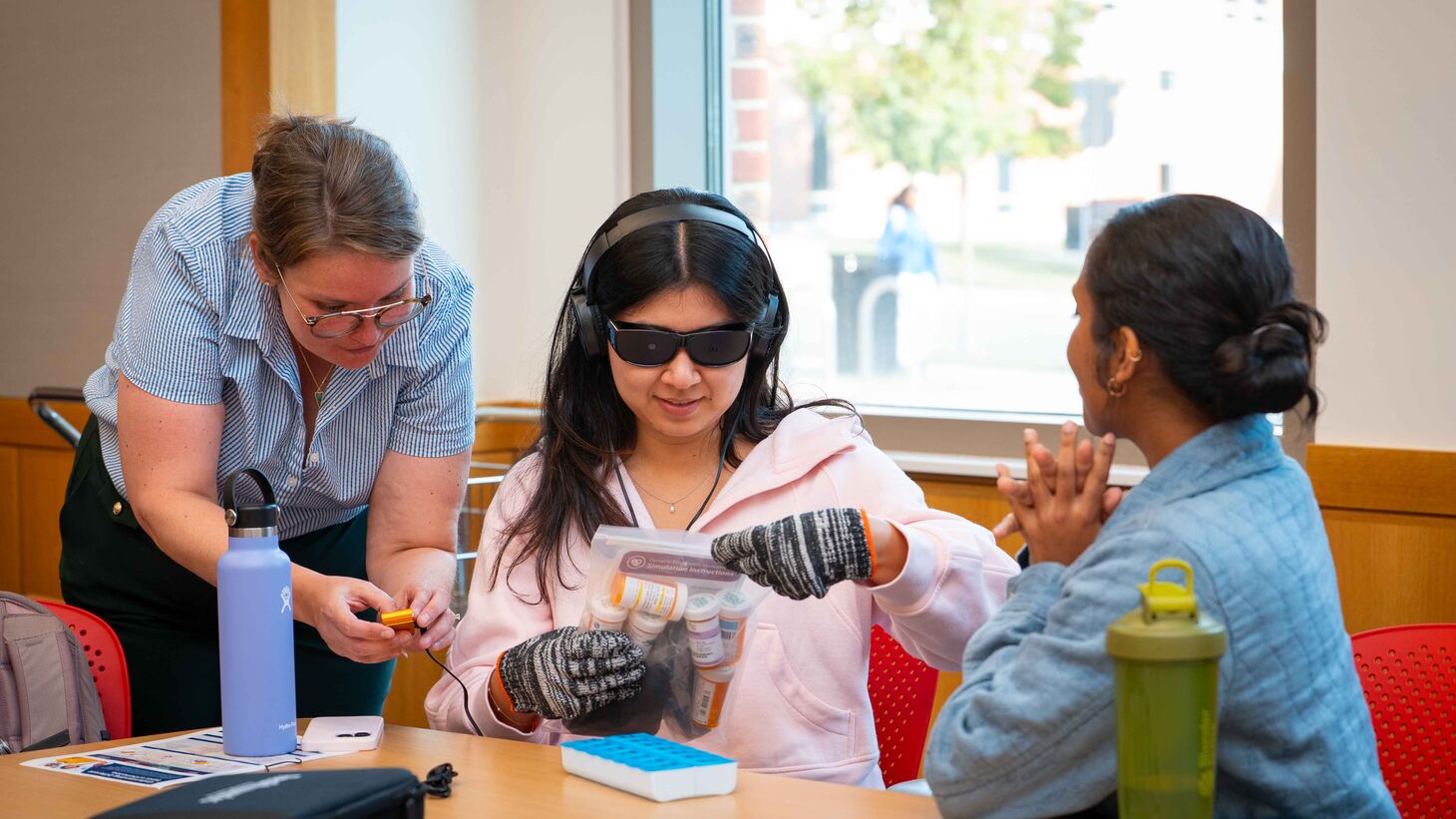 Morgan Angles (left) assists students in the simulation.