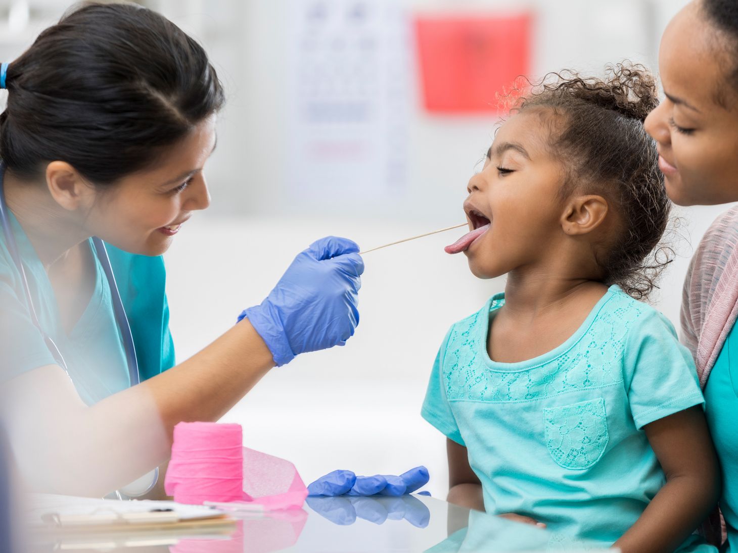 Nurse looking inside a child's mouth.