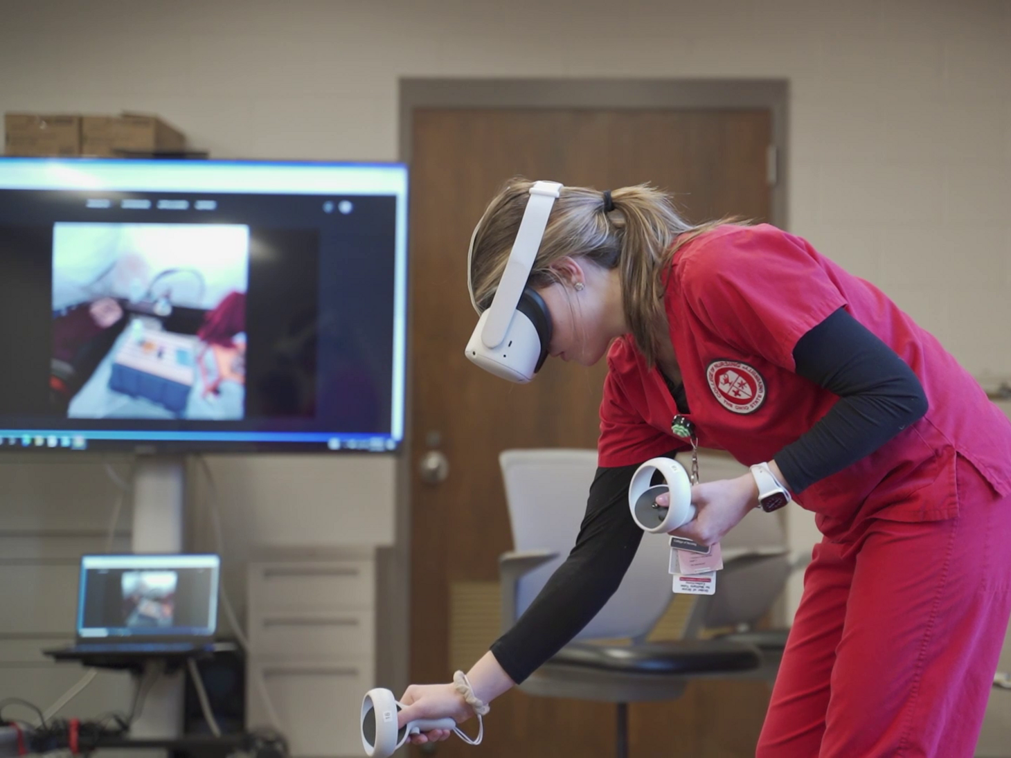 nursing student in red scrubs using virtual reality headset