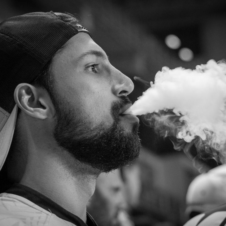 man blowing vape smoke