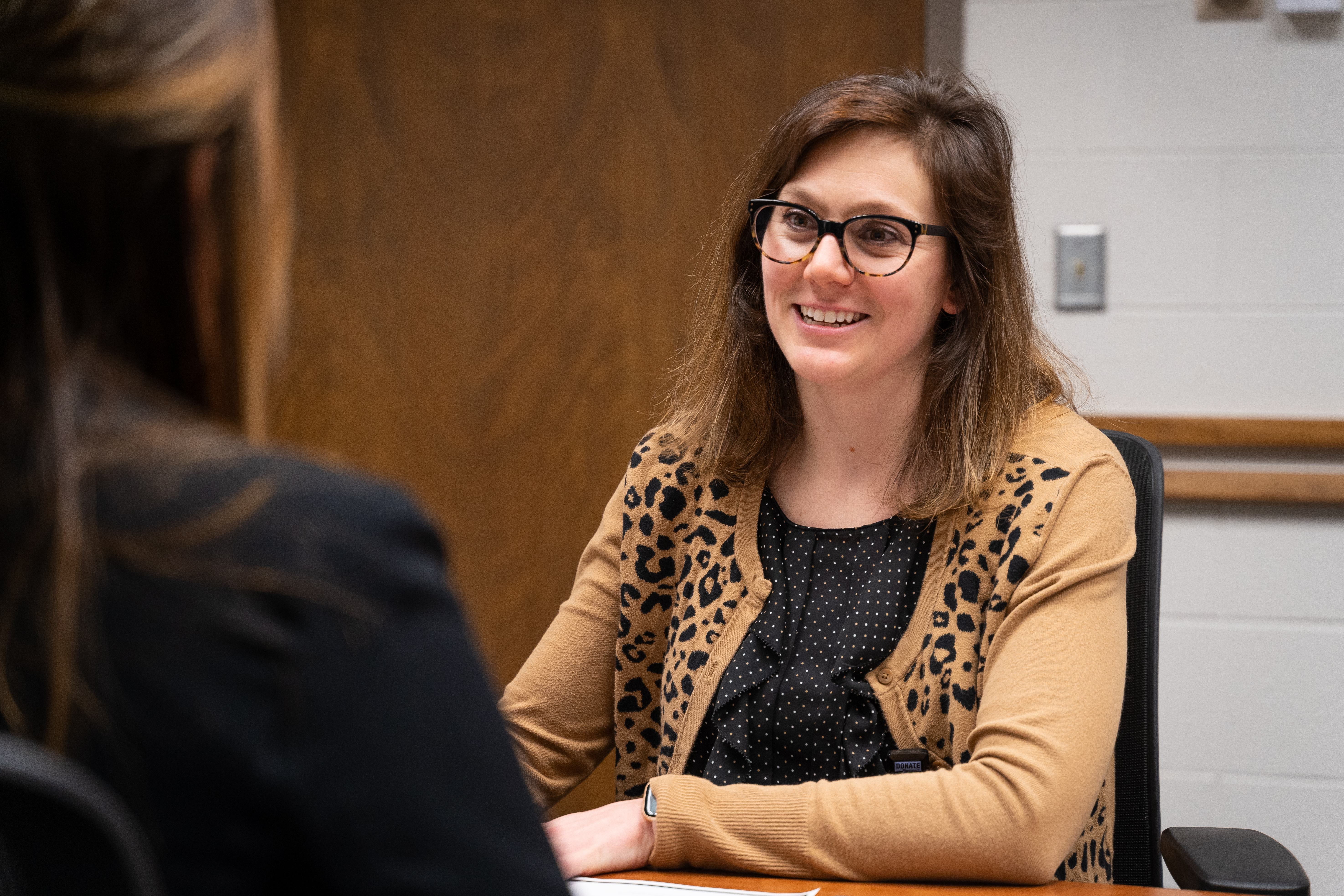 a person sits and talks with a student