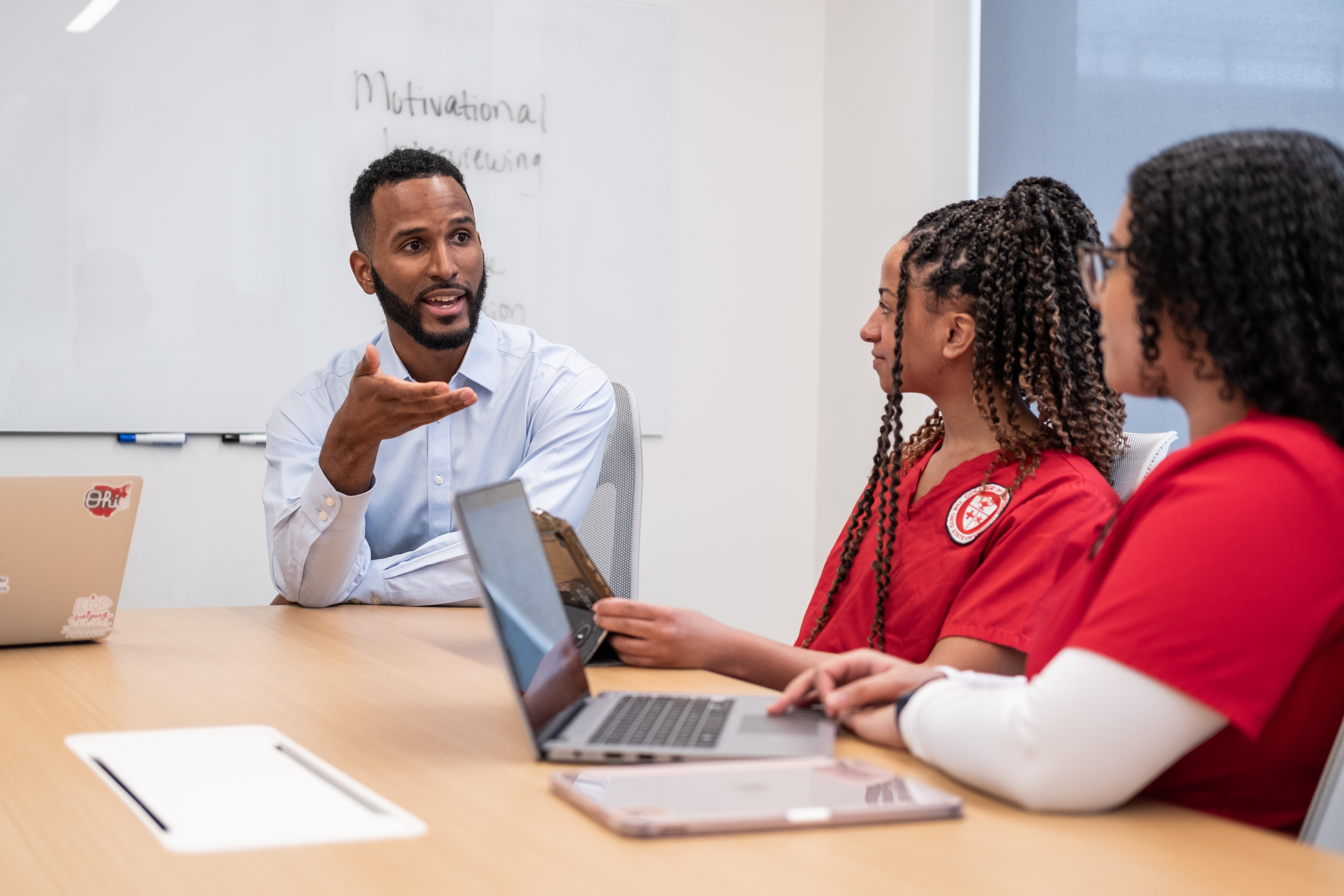 students sit in a classroom having a discussion with their instructor