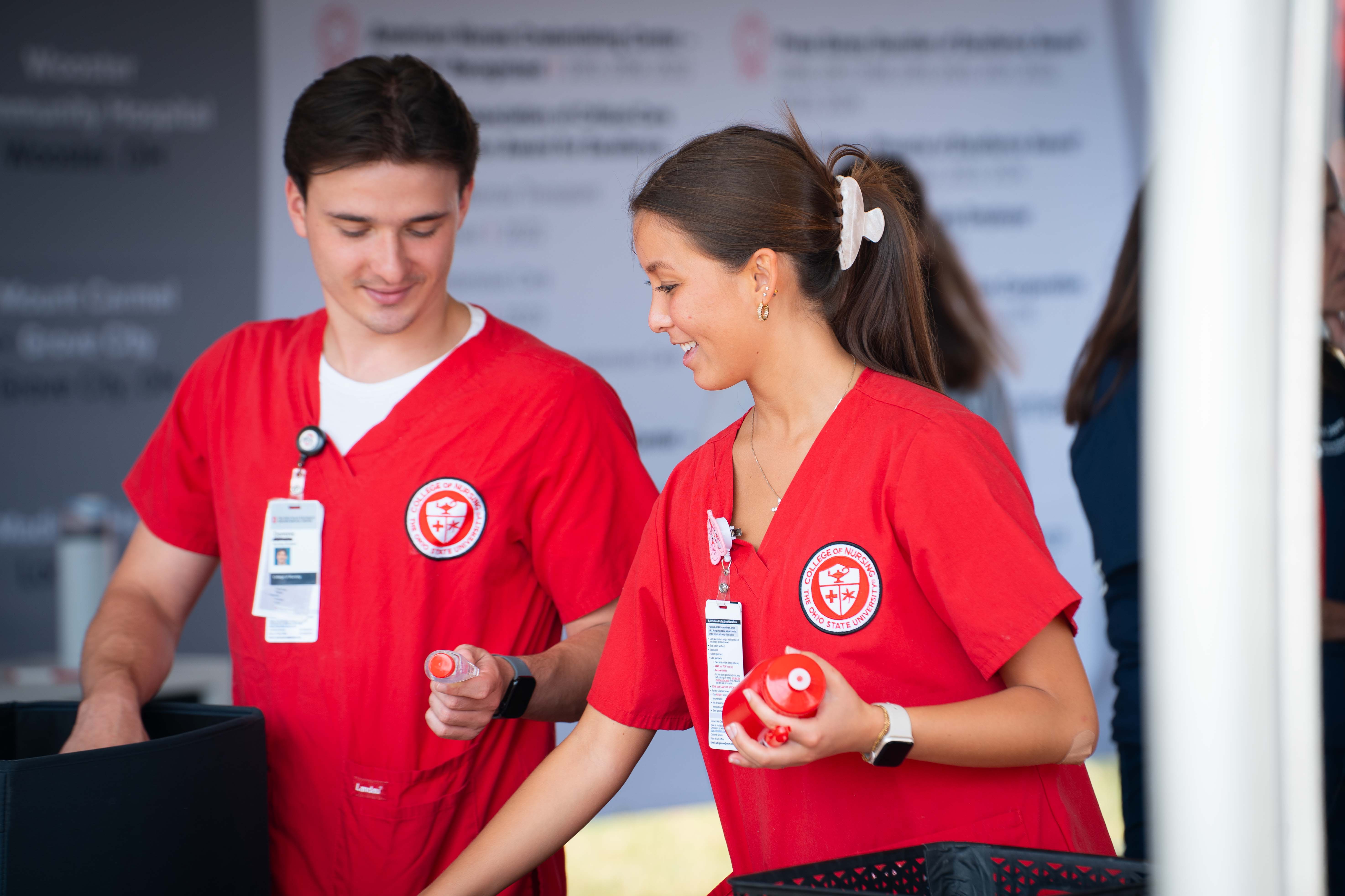 Nursing students passing out items during a community health event