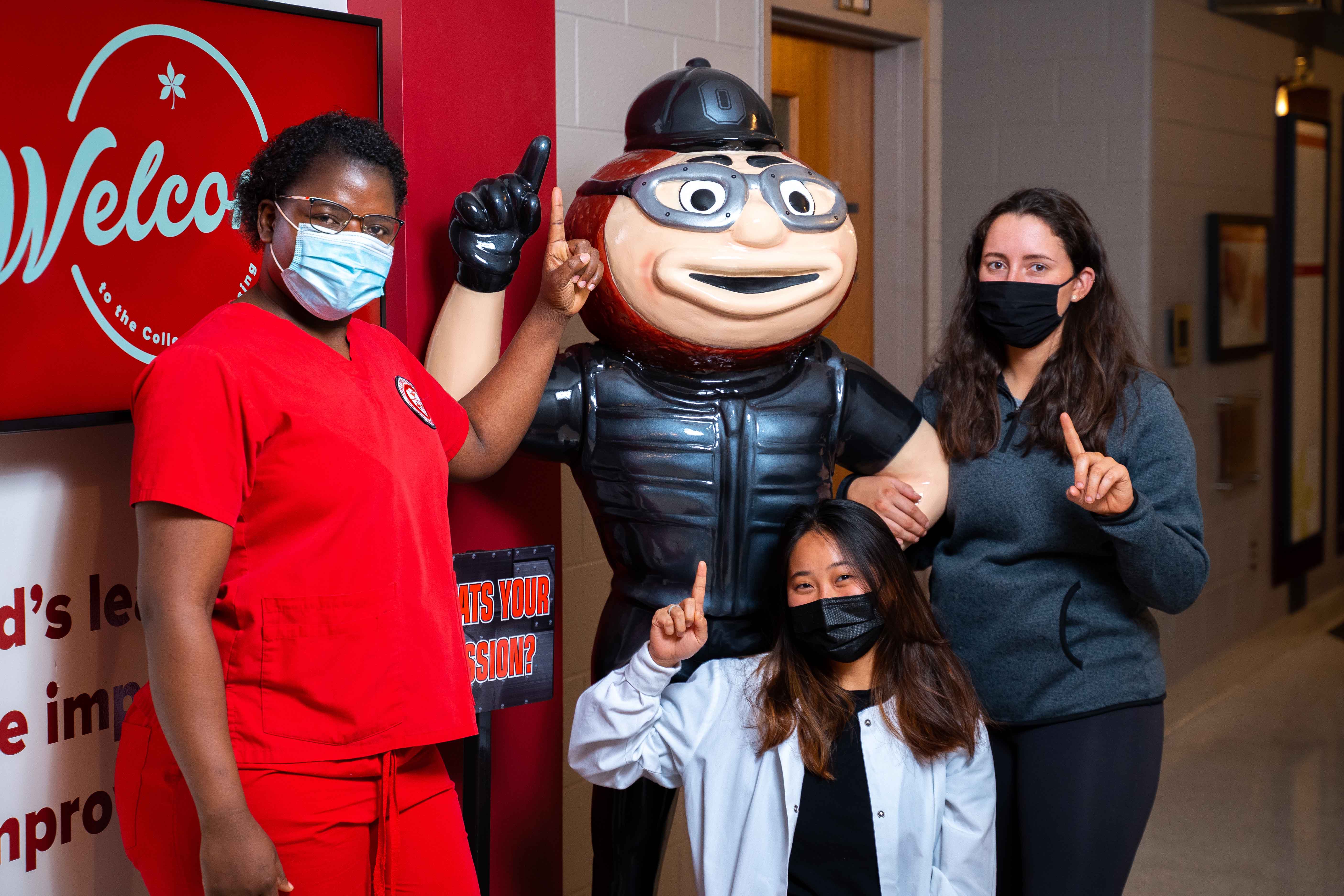 BSN nursing students Monicah Karera, Carolyn Zhang and Audrey Robinson pose with Mission Impossible Brutus in Newton Hall