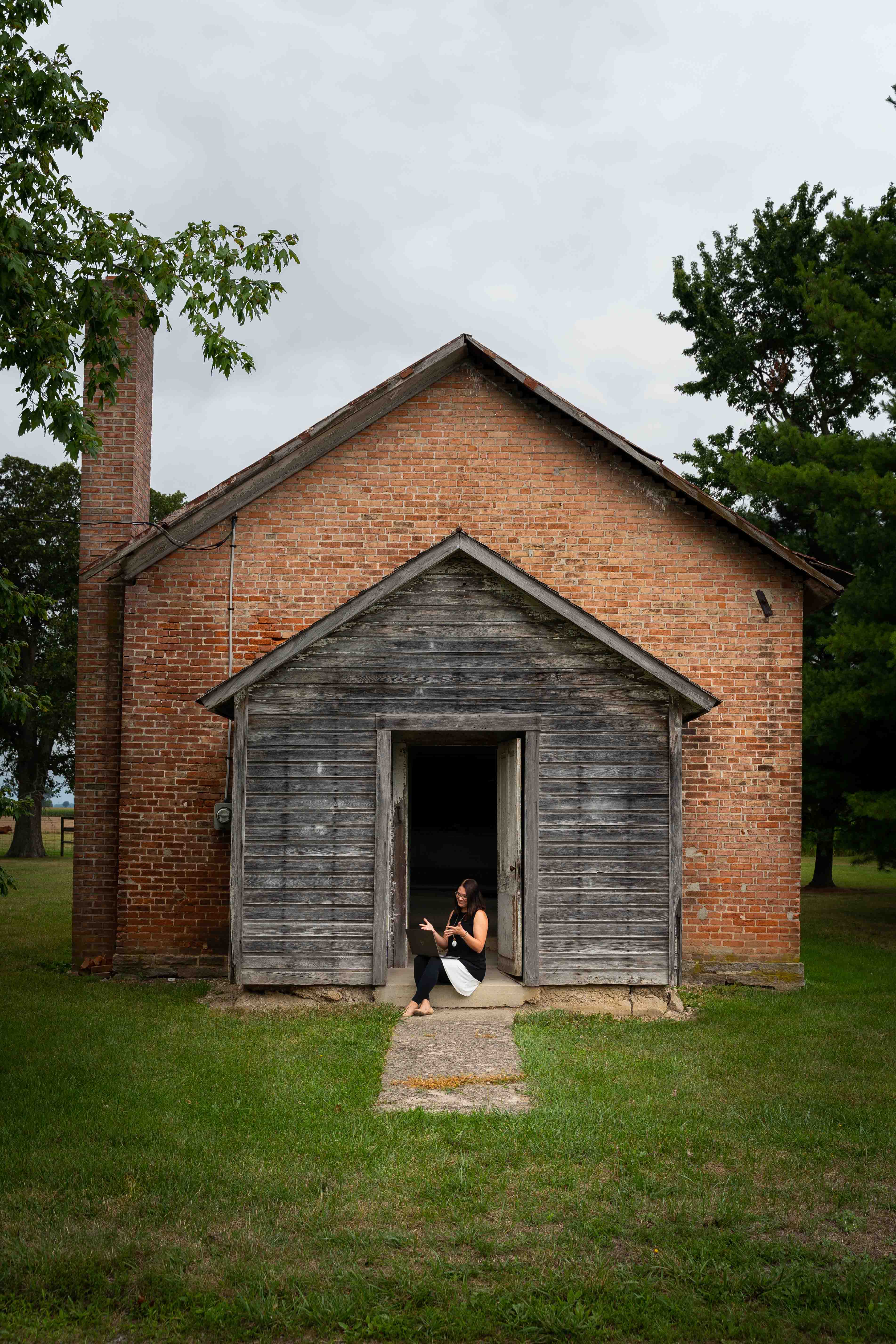 Christa Newtz in front of old schoolhouse