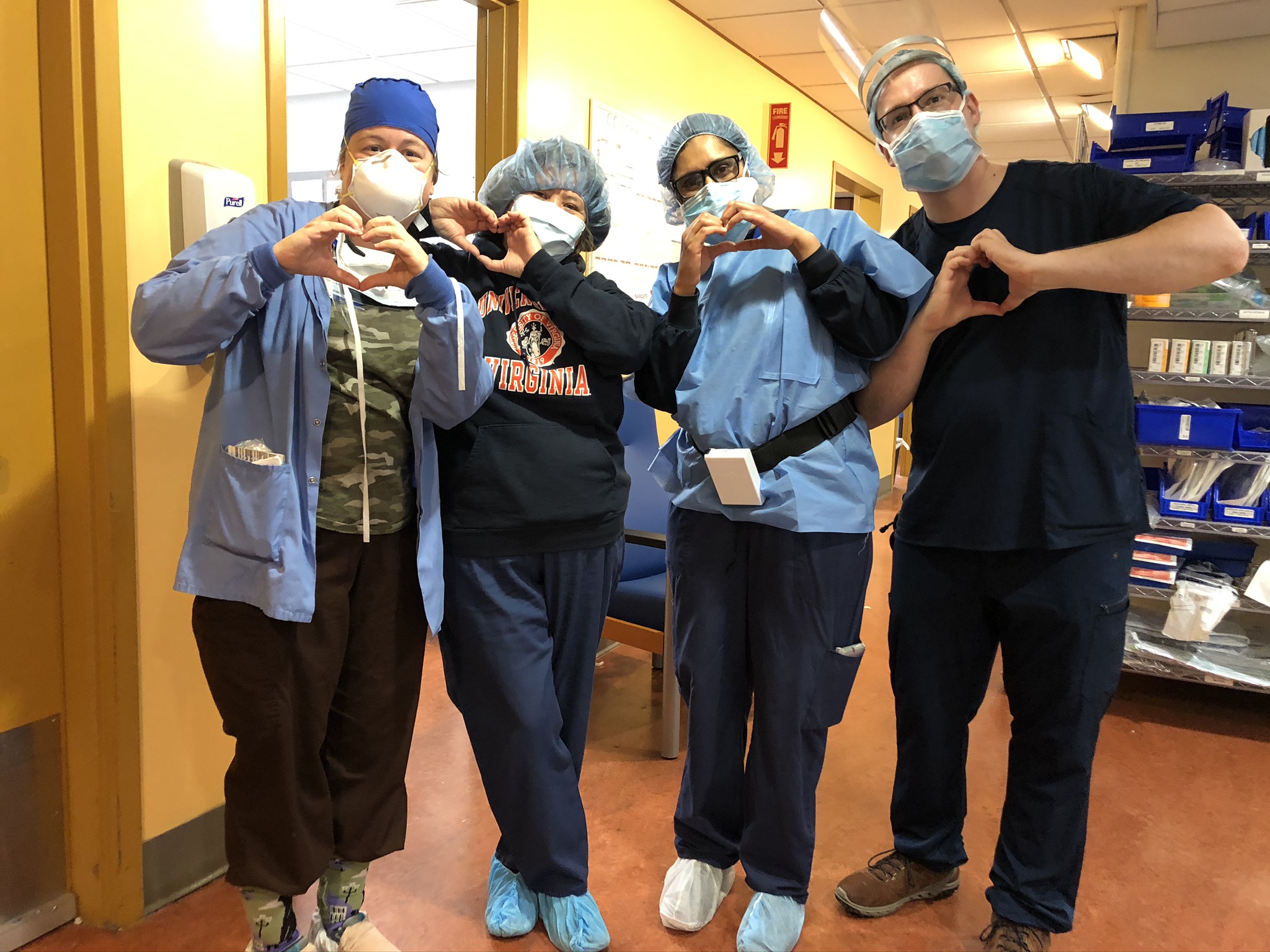 Kelly Casler and her friends wearing PPE making heart shapes with their hands