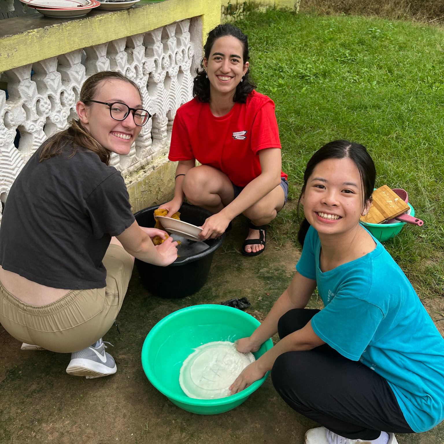 student volunteers washing dishes outside