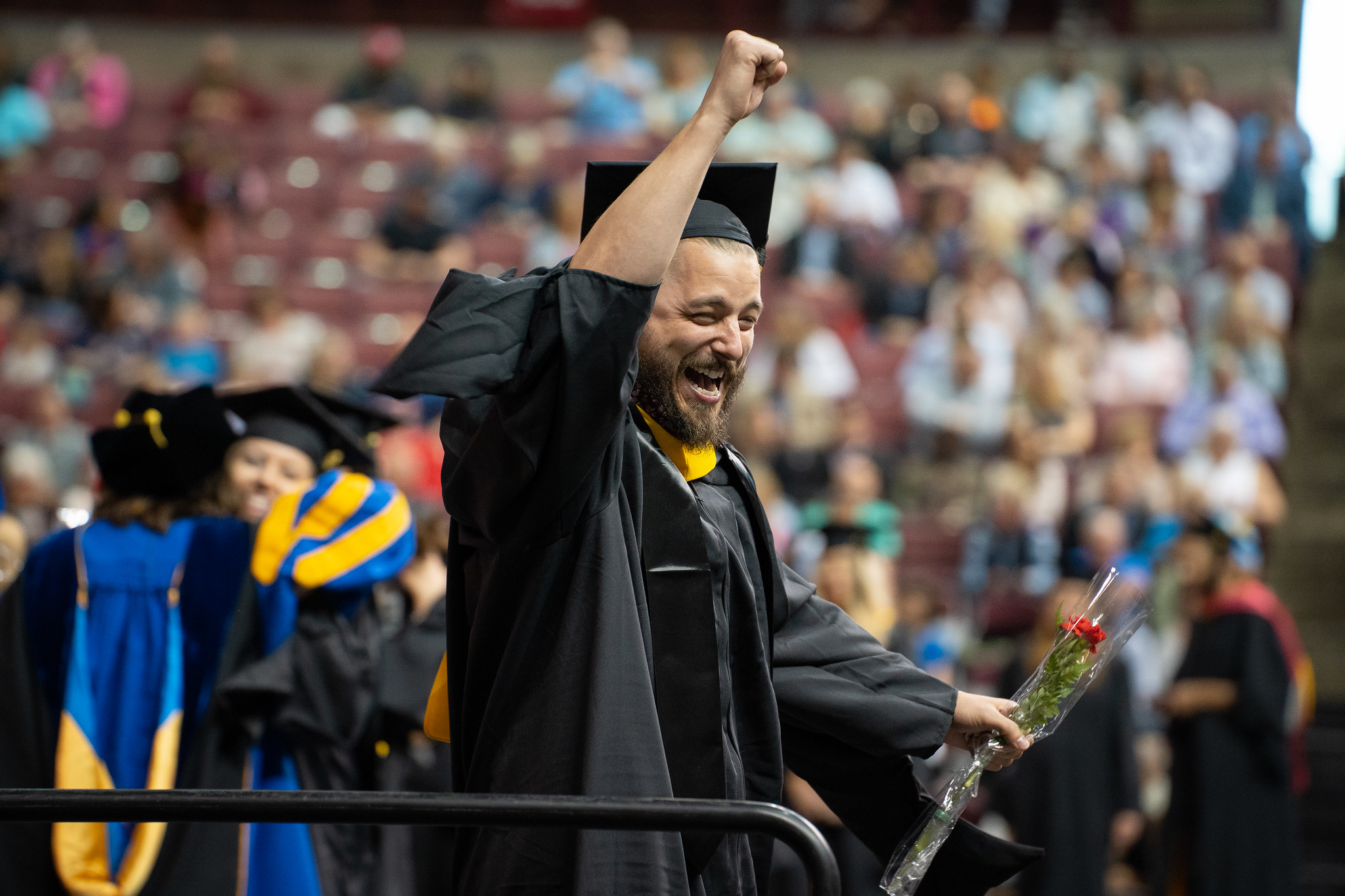 graduate pumps fist in the air after receiving diploma