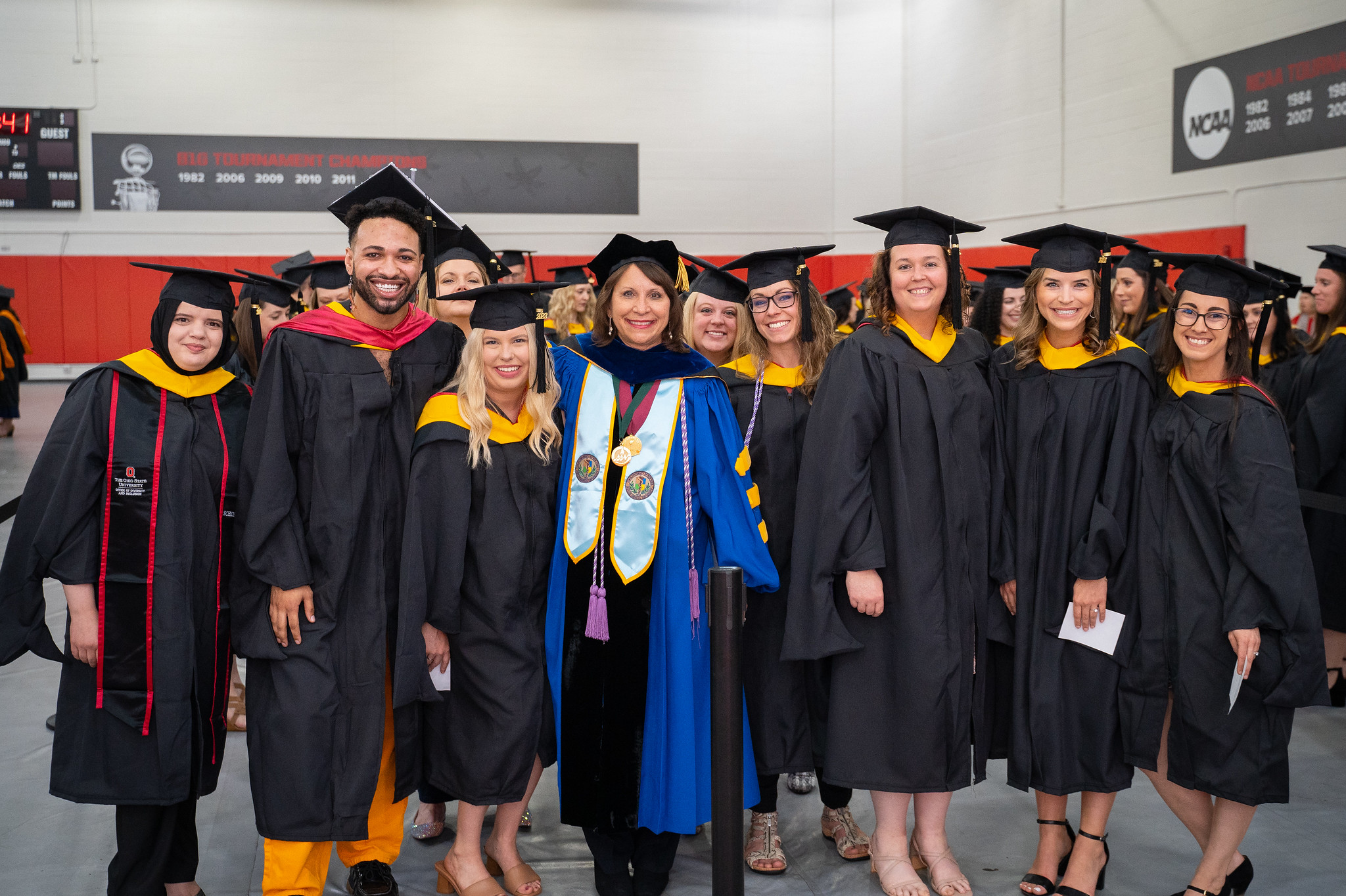 group of graduates pose with Dean Melnyk before the Convocation ceremony
