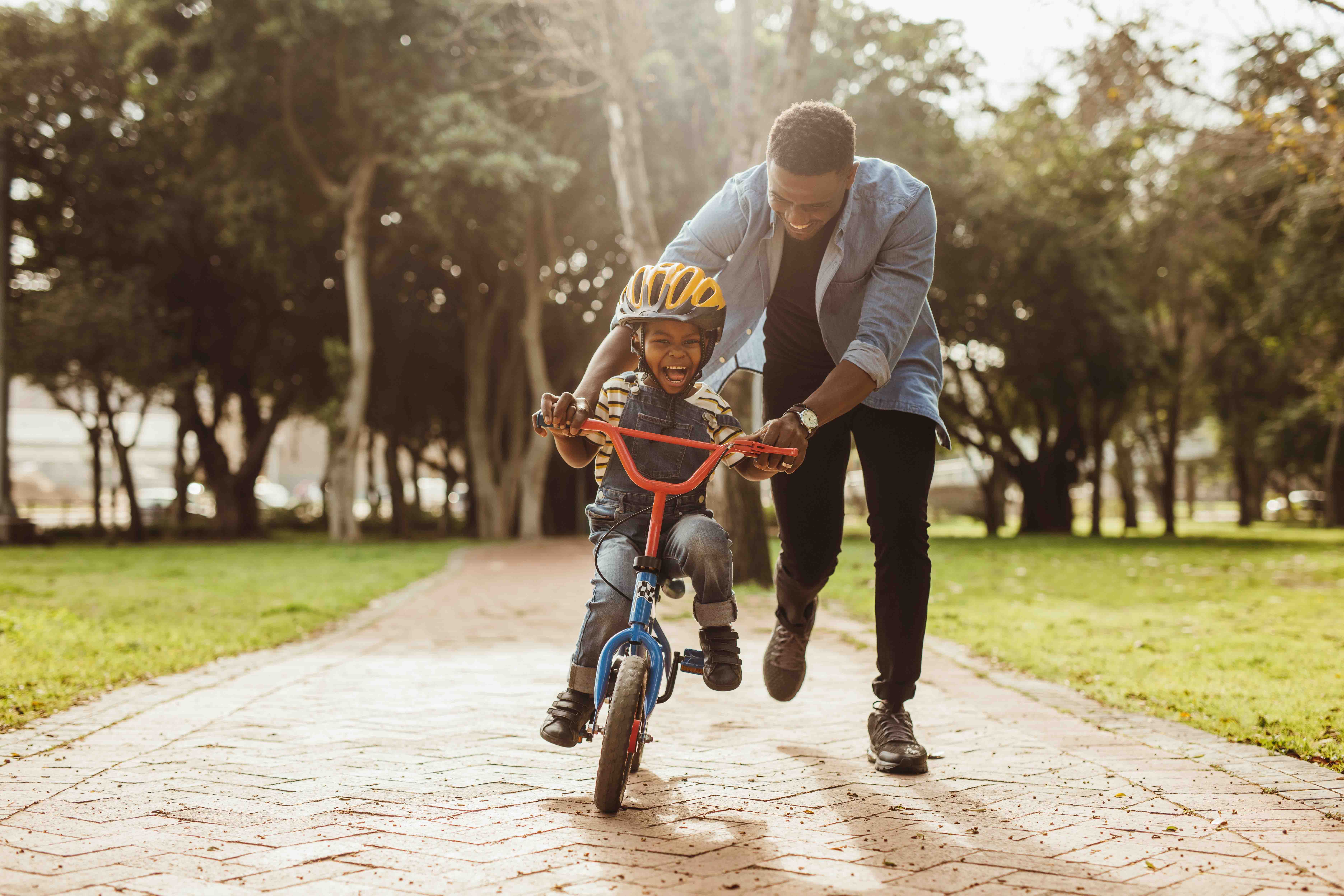 man helping young boy ride a bike