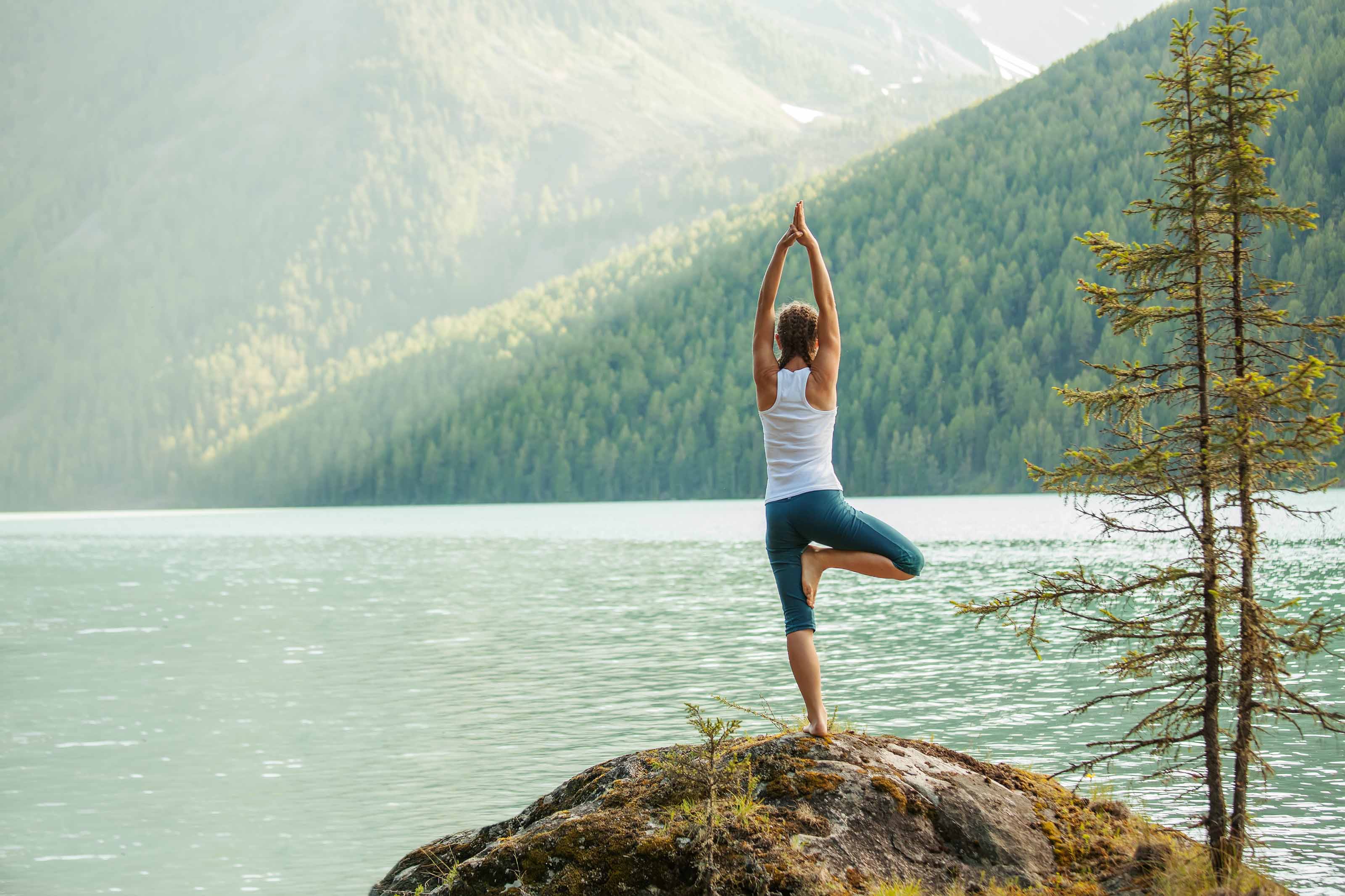 woman doing yoga by a lake