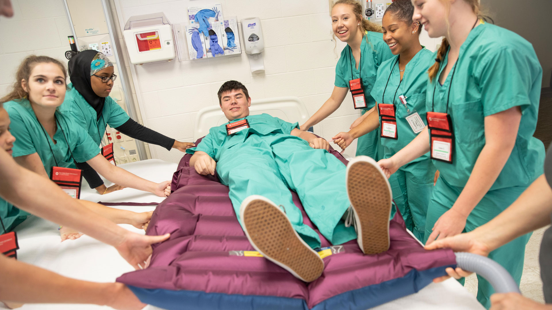 participants in the summer institute for future nurses program team lift a young man