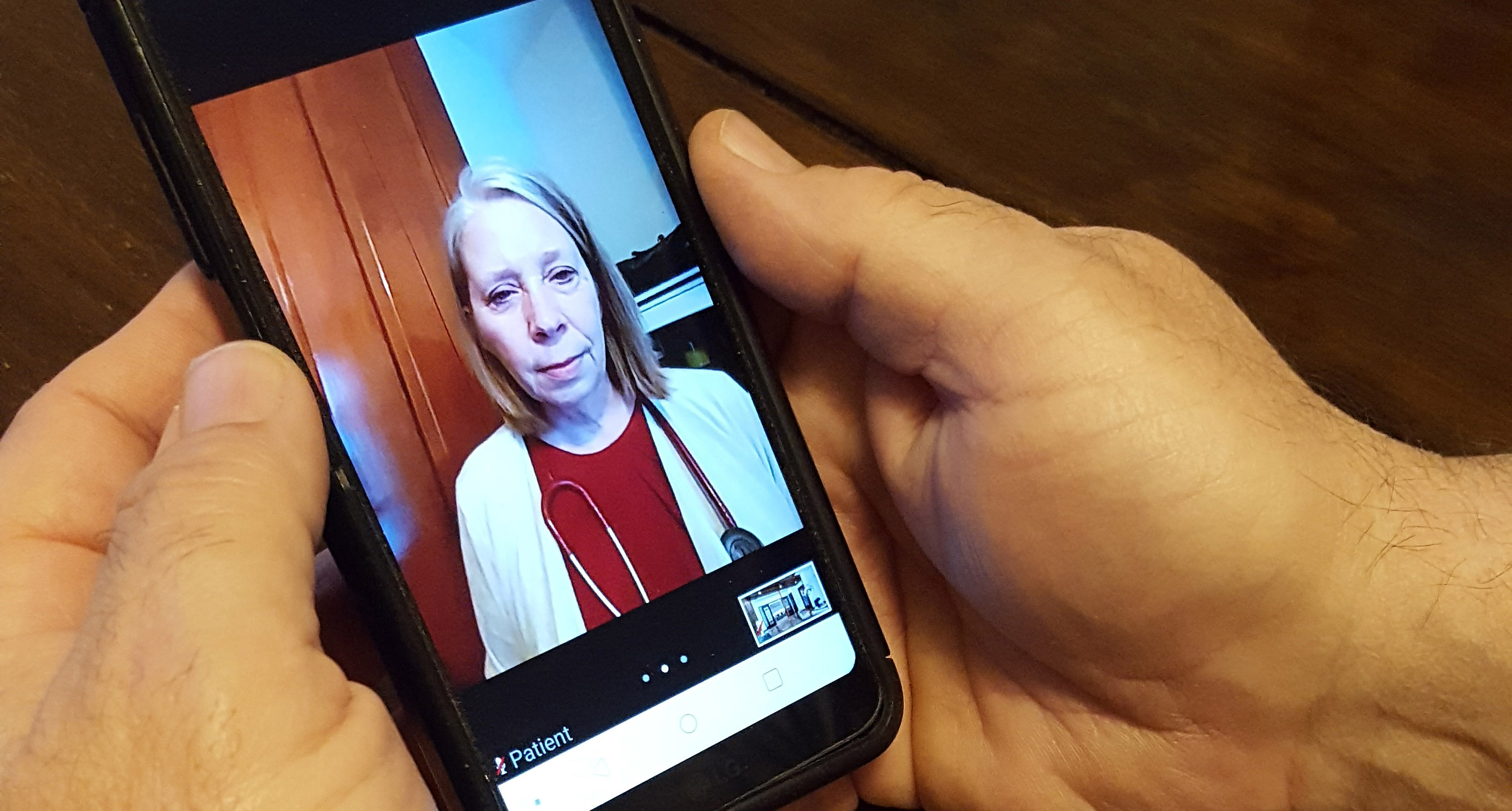 hands holding a cell phone while on a video call with Alice Teall