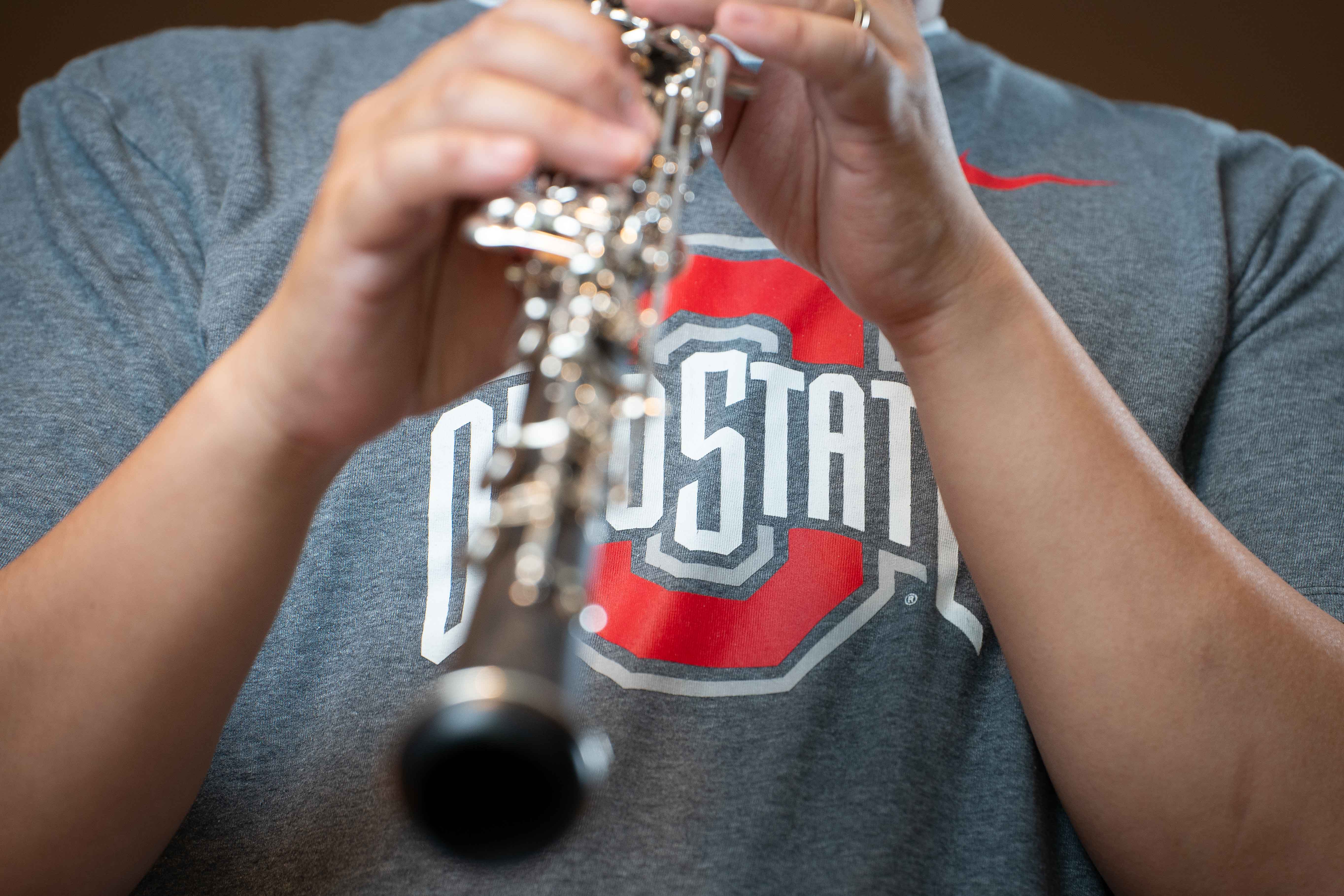 Chris Connors playing the oboe while wearing an OSU shirt