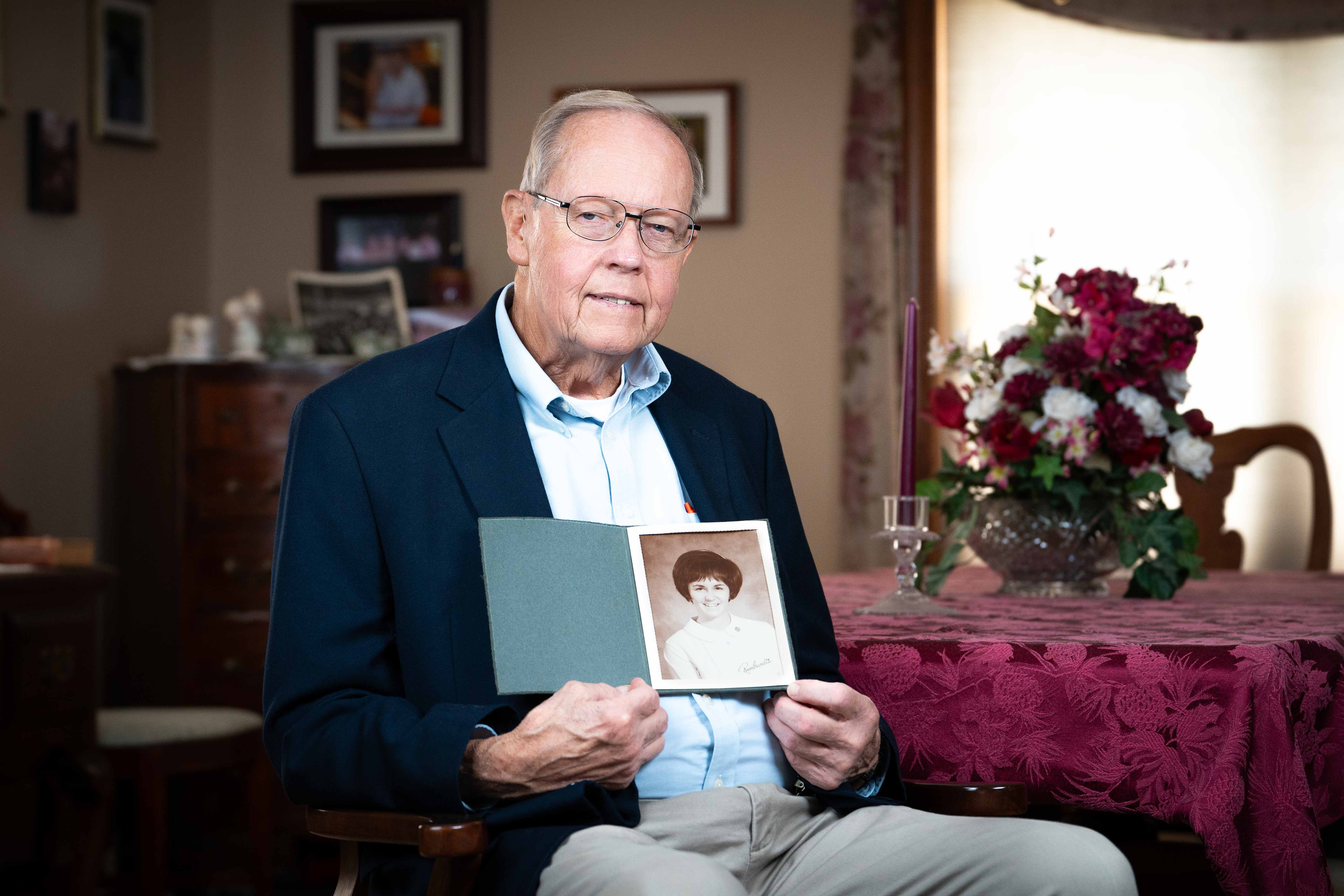 David Hiatt holds a photo of his wife, Sandy.