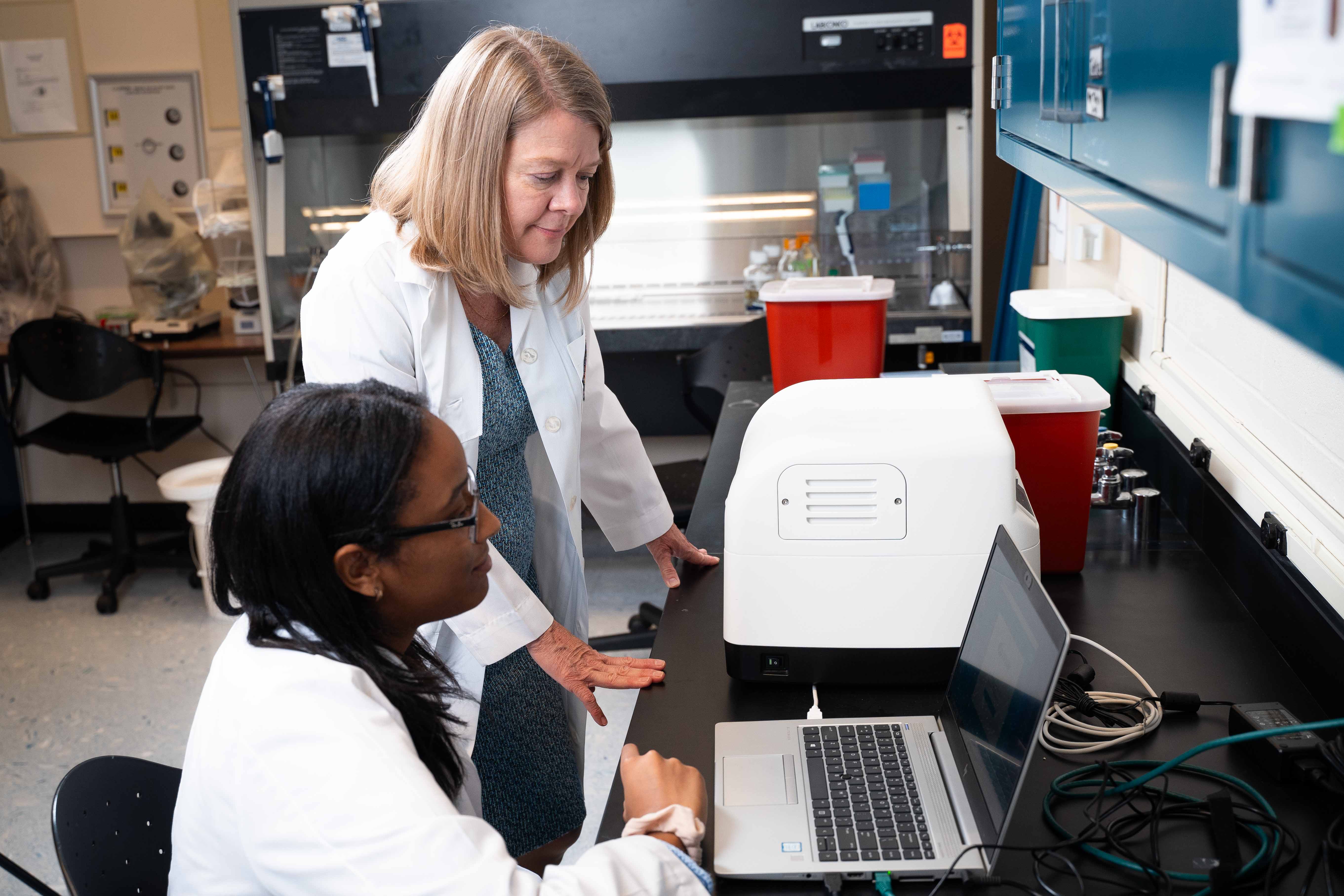 Lab technician Abeir Khalid and Jodi Ford look at cortisol results collected from hair samples at the Stress Science Lab.