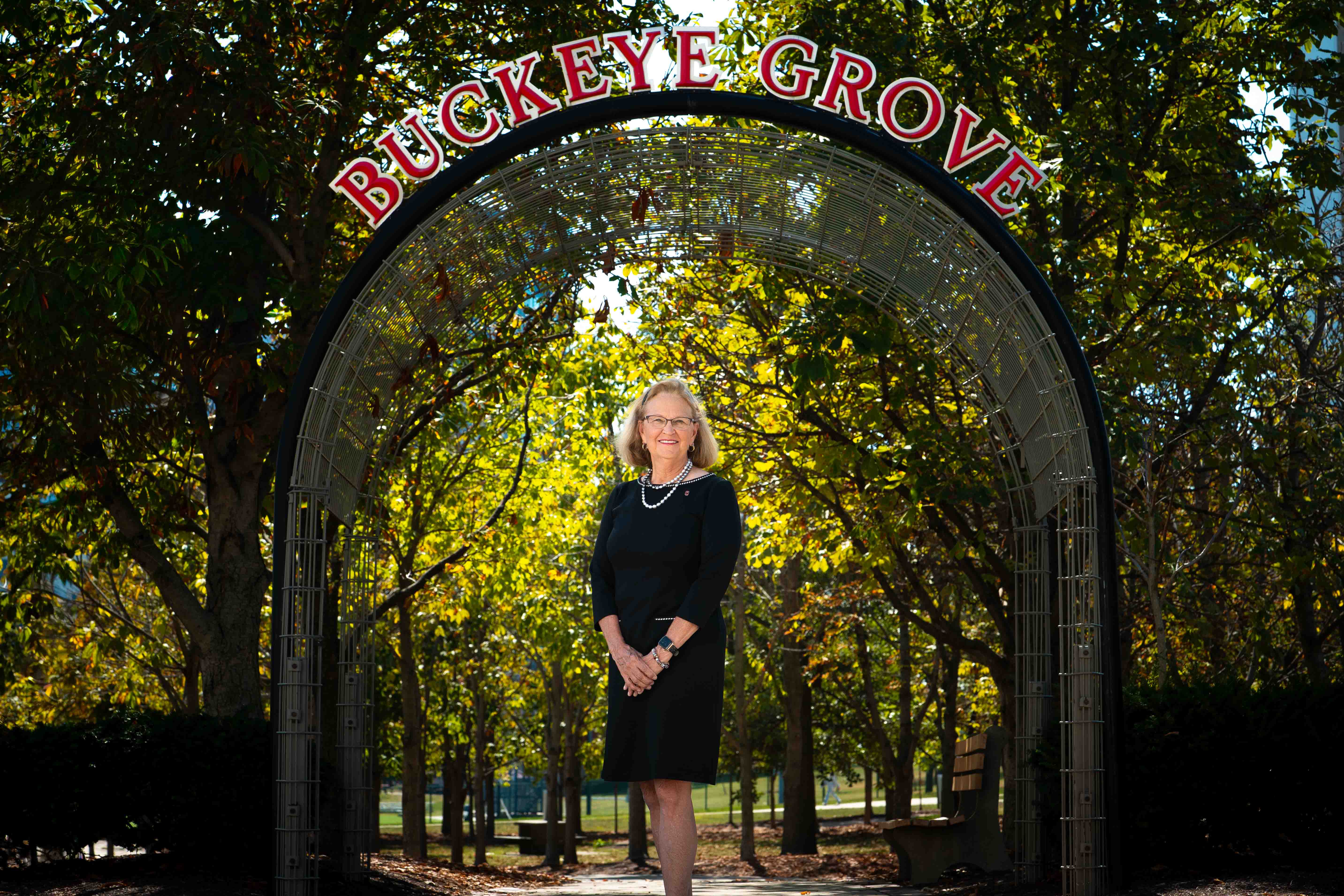 Jackie Buck poses in front of the Buckeye Grove sign