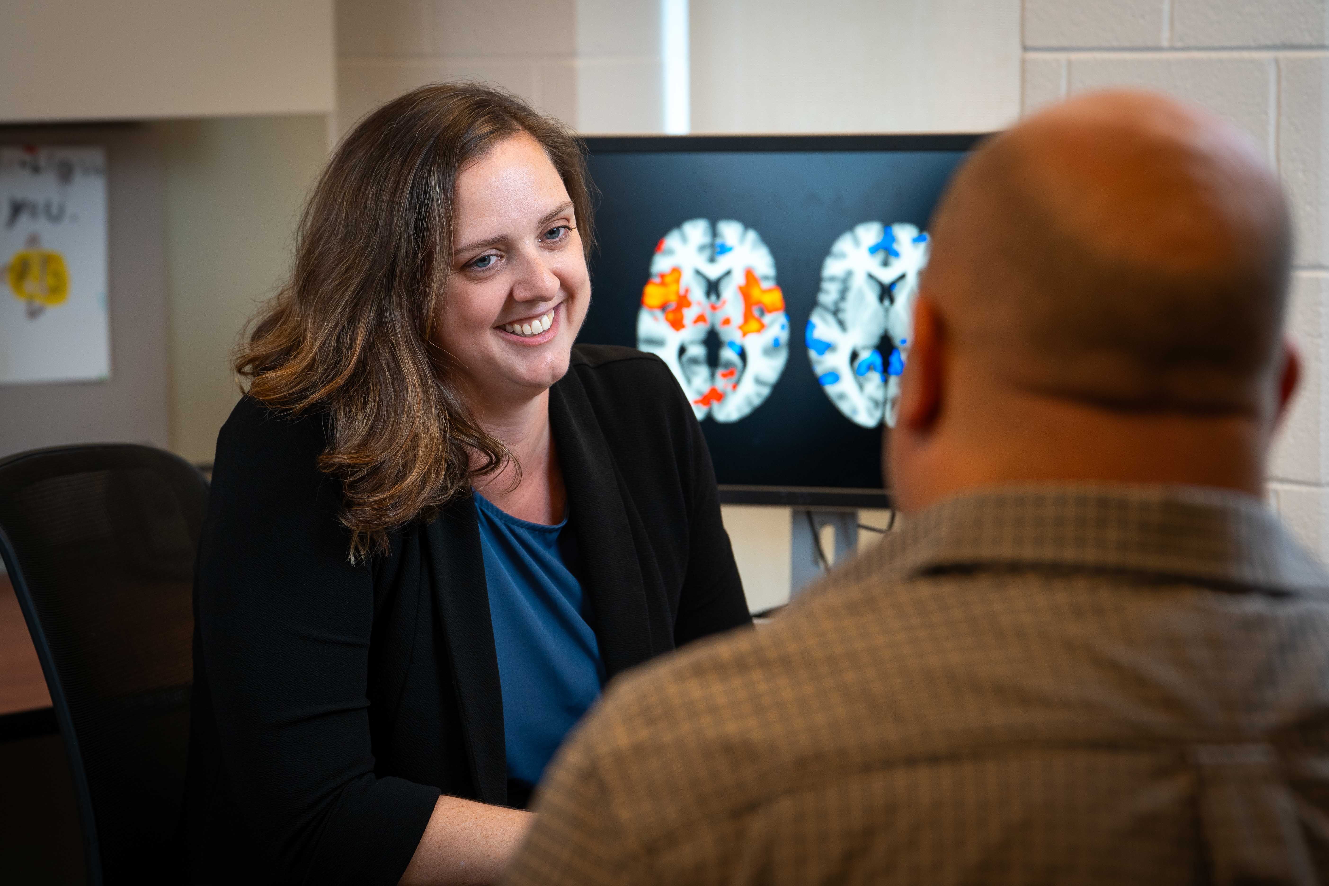 Failla explains brain images from a pain study to postdoctoral trainee Jeffrey Boon