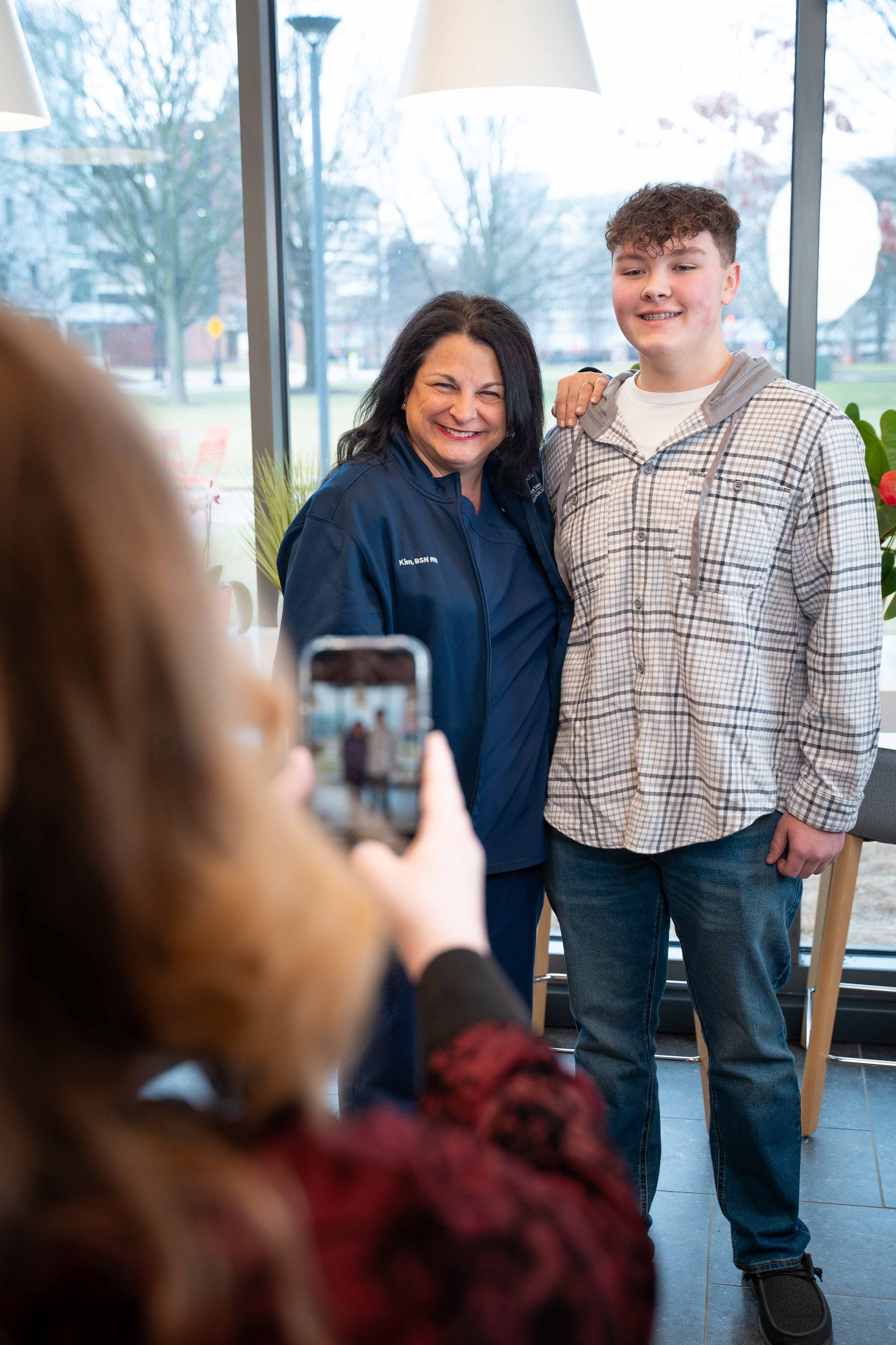 Dominic's mother taking a photo with her cell phone of Dom and Kim together