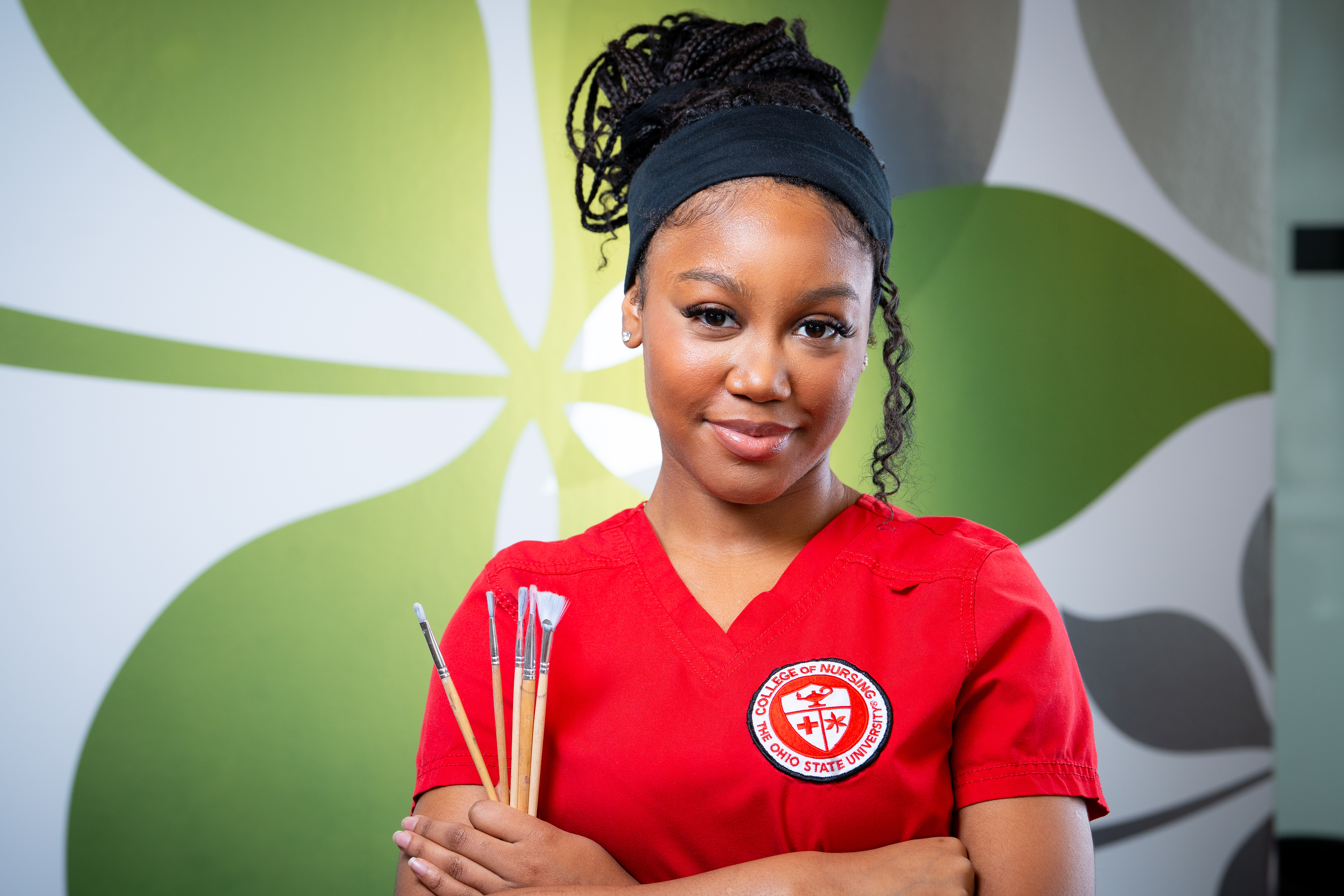 Briana Gordon holding paintbrushes