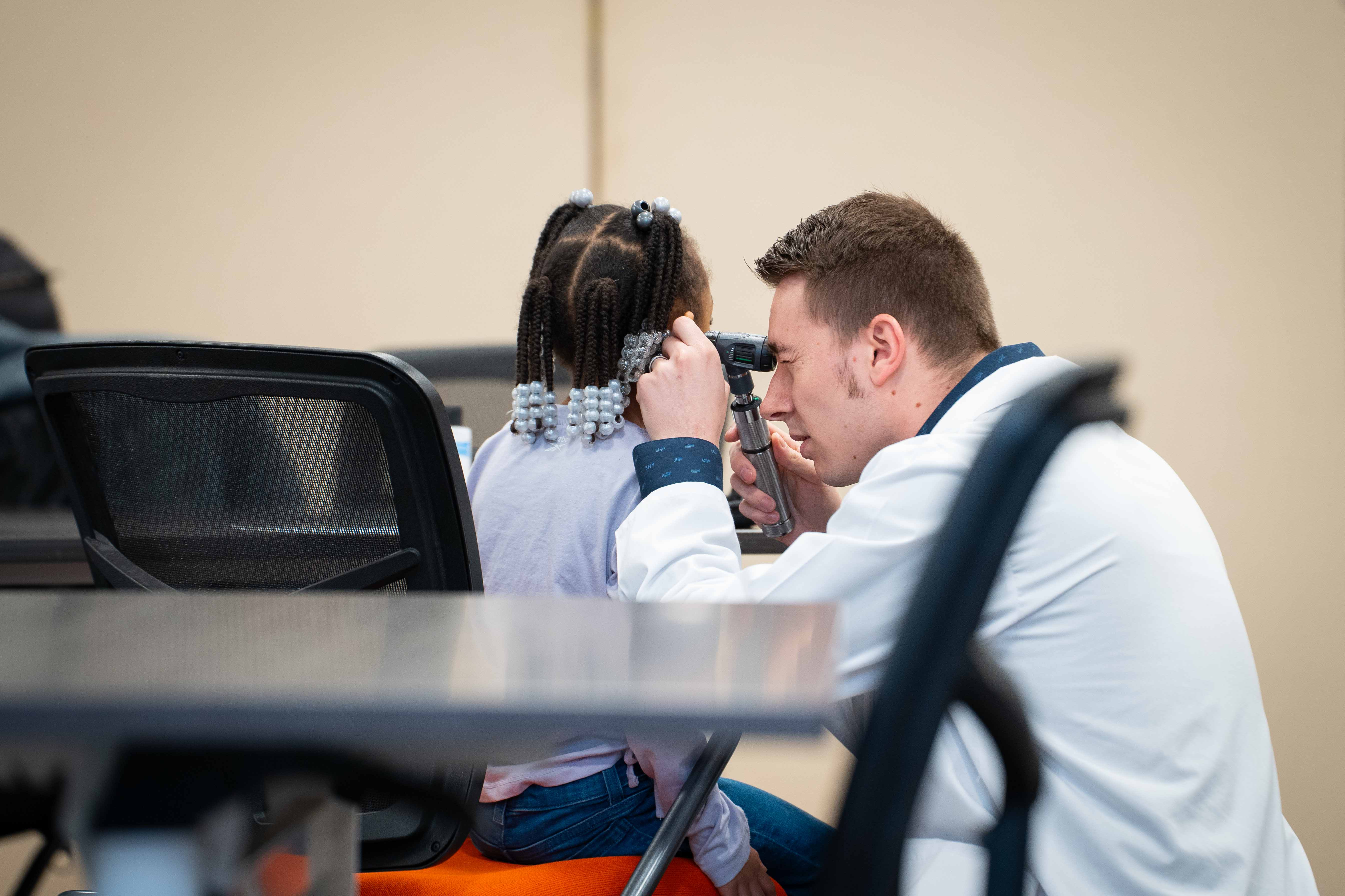 FNP student Joey Fickes takes a child's blood pressure.