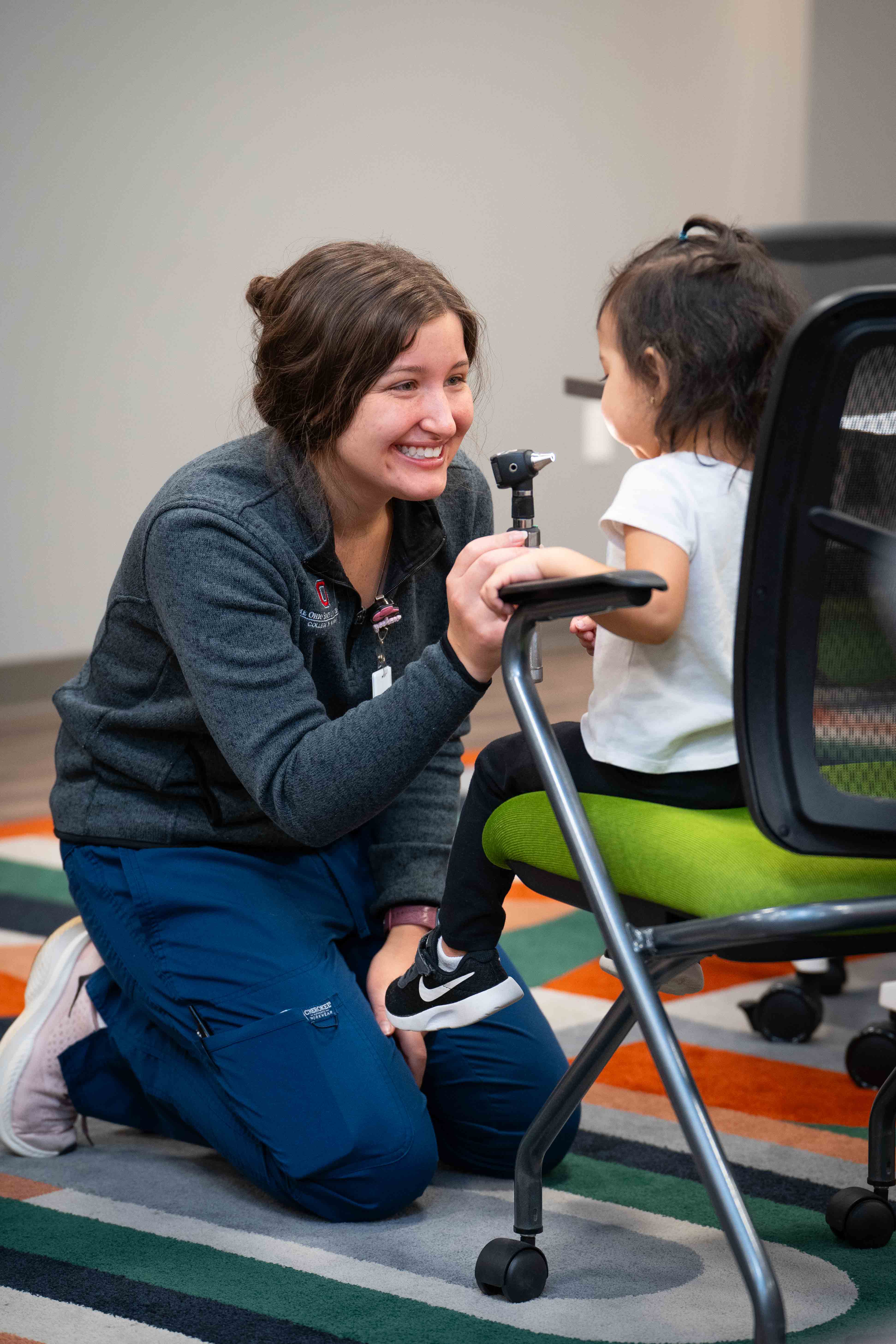 Peyton Mast gets a young Head Start student comfortable with an otoscope.