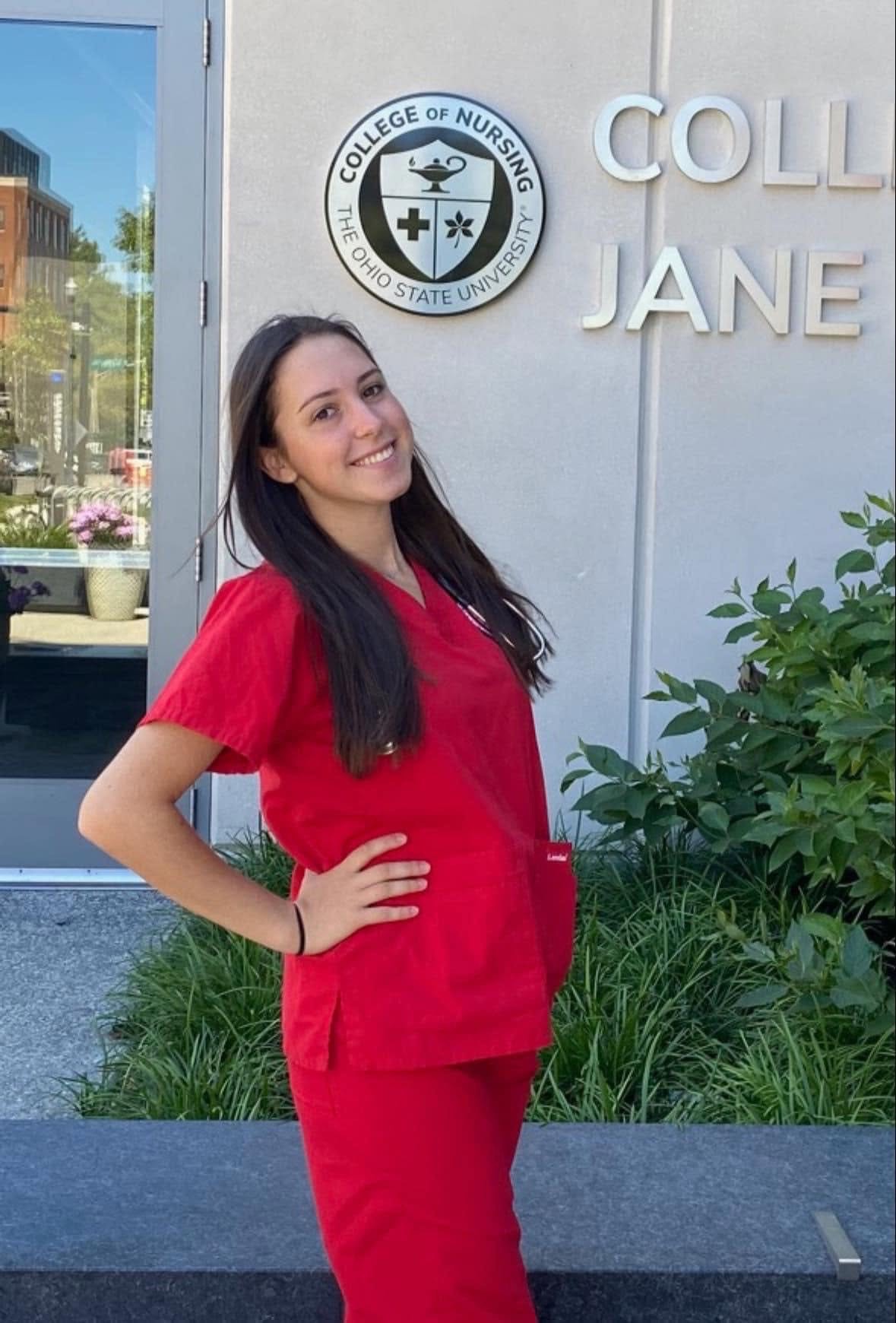Charley Bauer wearing her red scrubs in front of Jane E. Heminger Hall. 