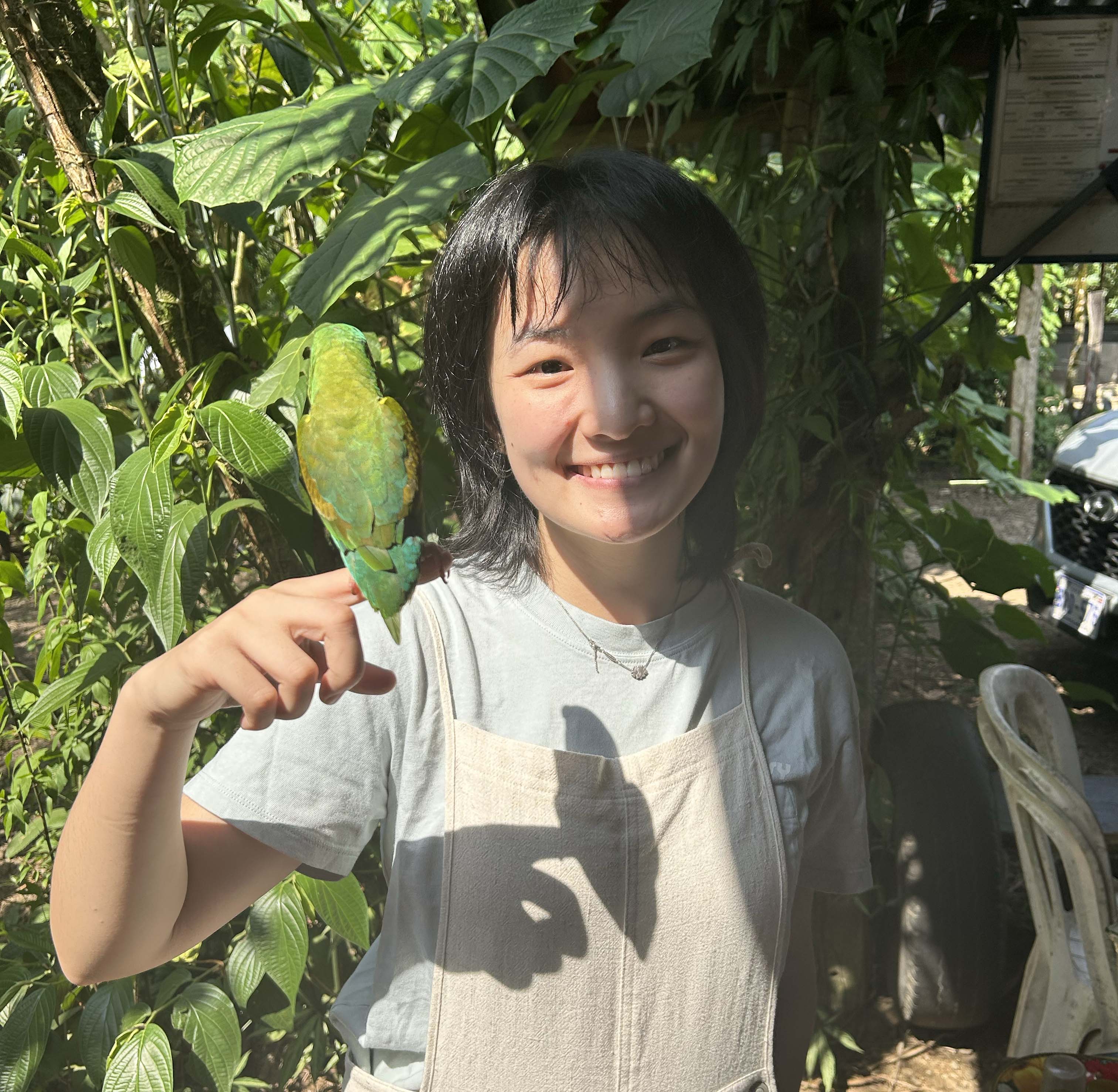 Yang Du holding up a bird that's on her finger