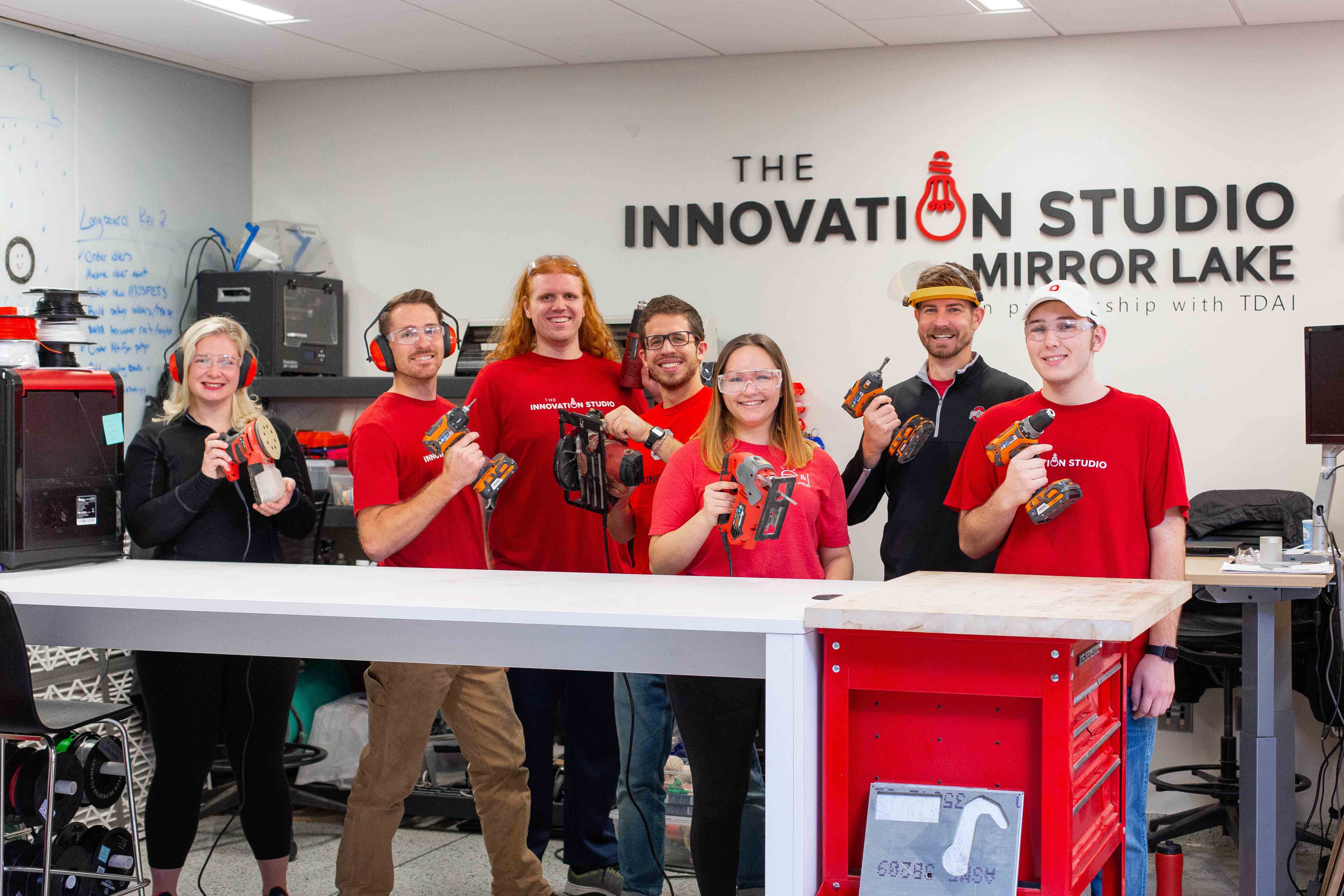 The Innovation Studio holding up power tools in the studio