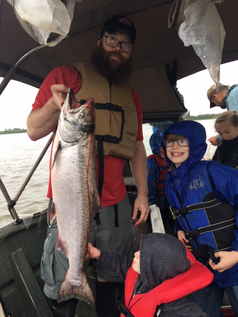 Corey Zink holding a large fish on a boat