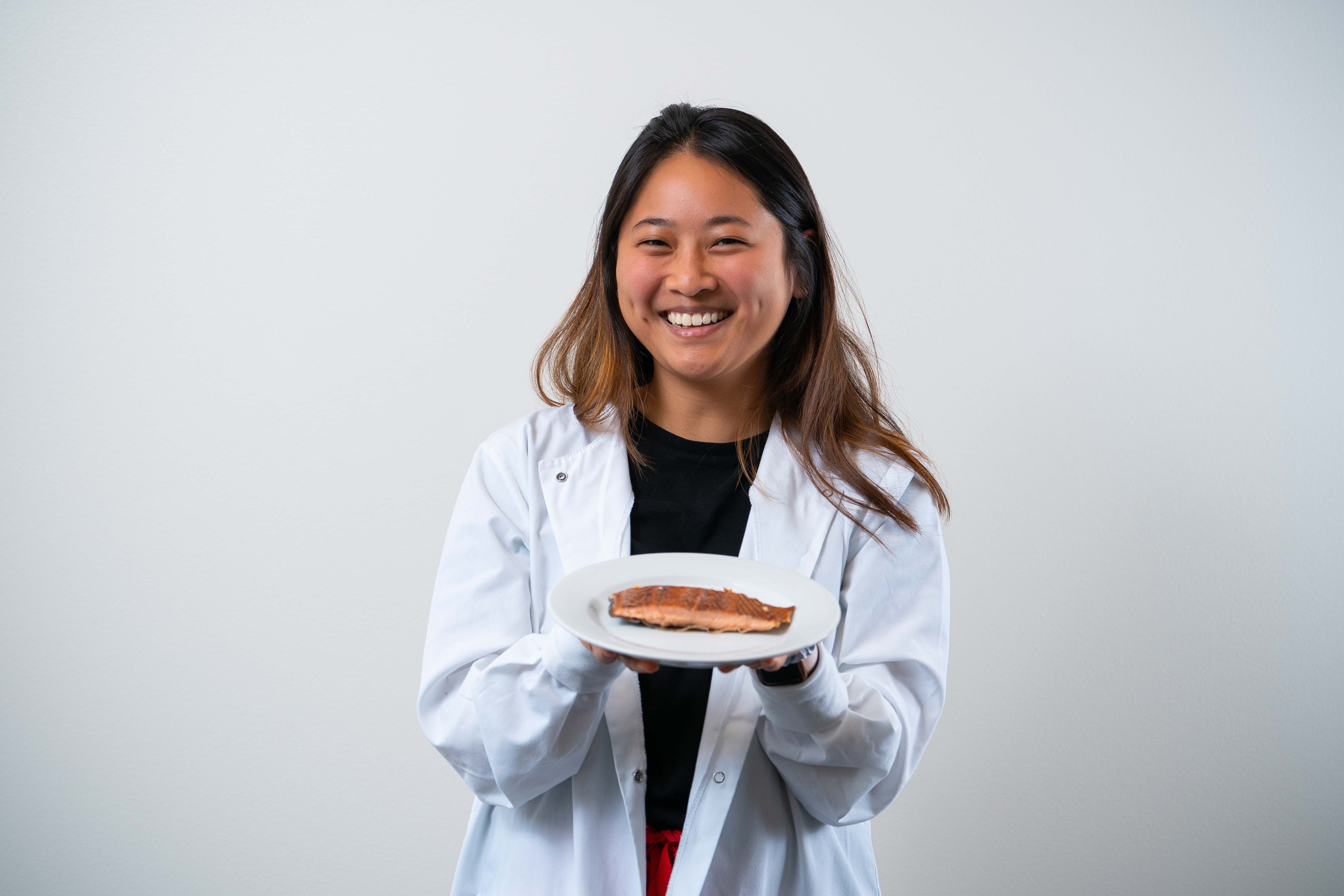 Carolyn Zhang holding a plate of salmon