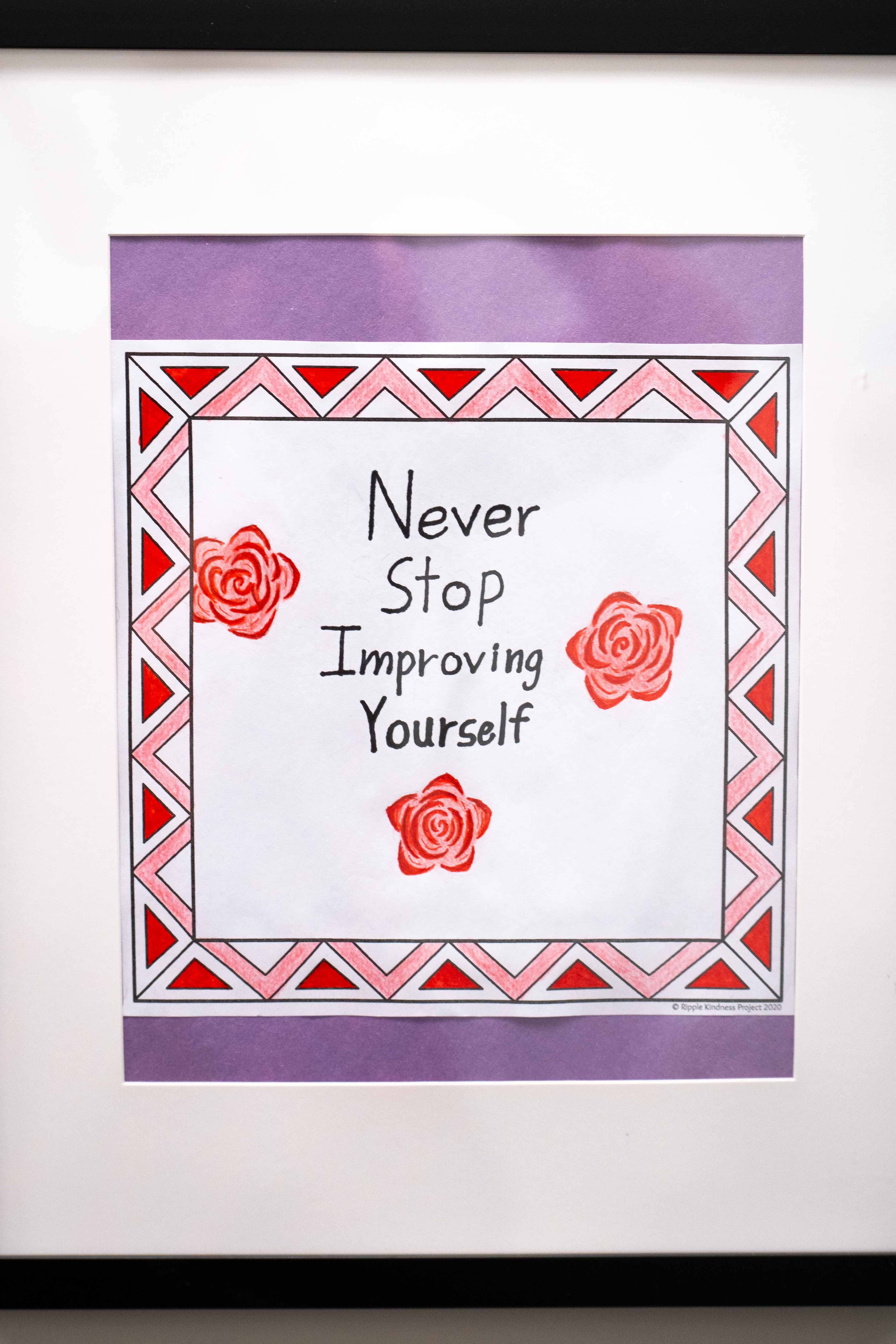 Framed student artwork that reads, "Never stop improving yourself"