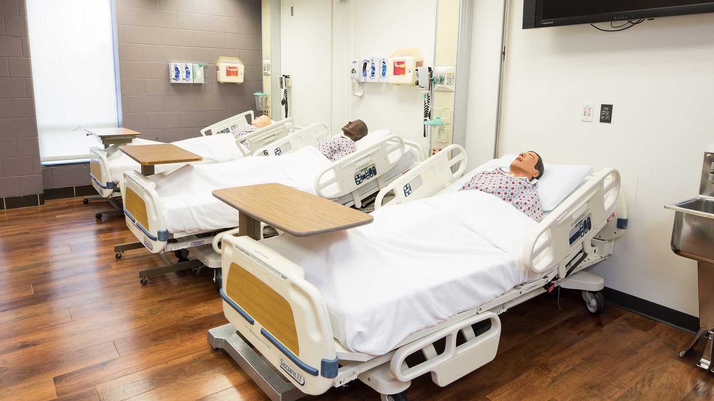 three hospital beds with human patient simulators