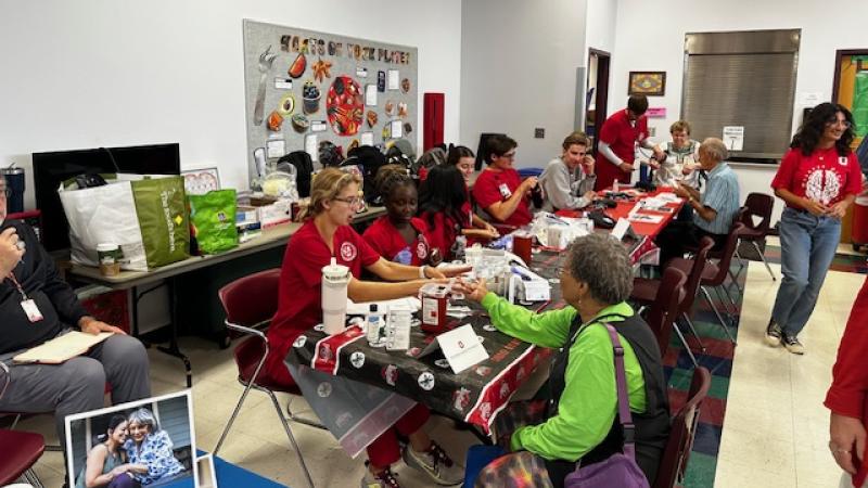 Ohio State nursing students providing health screenings including blood pressure and glucose monitoring.