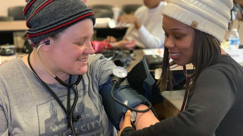 Community Health Workers training each other to take blood pressure reading