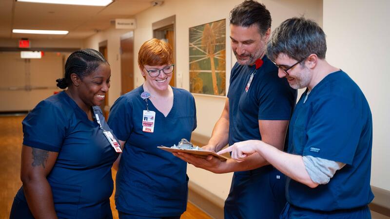 nurse leader discusses patient chart with registered nurses