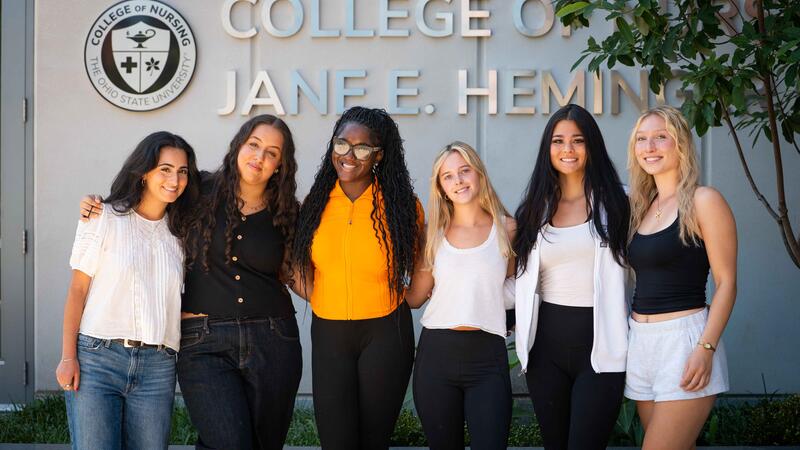 nursing students pose in front of Jane E. Heminger Hall sign