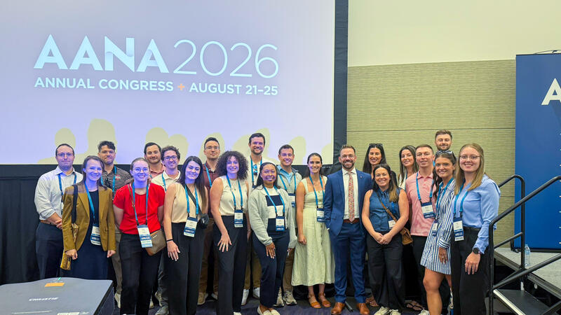 nurse anesthesia students and faculty pose for a photo in front of conference screen