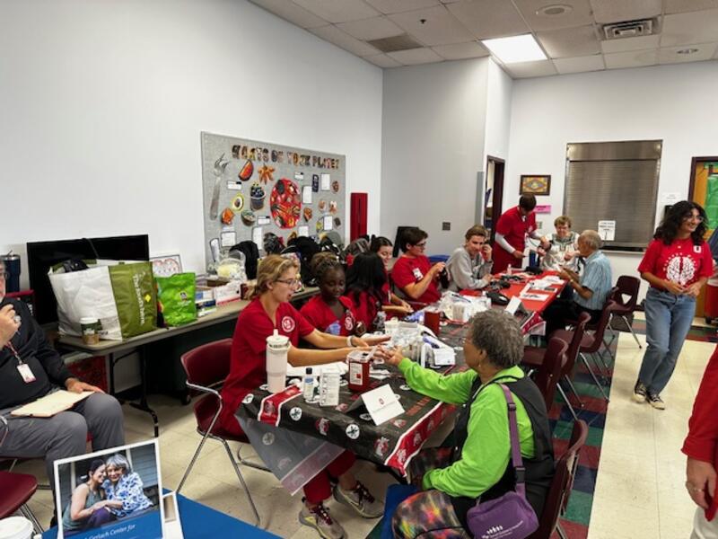 Ohio State nursing students providing health screenings including blood pressure and glucose monitoring.