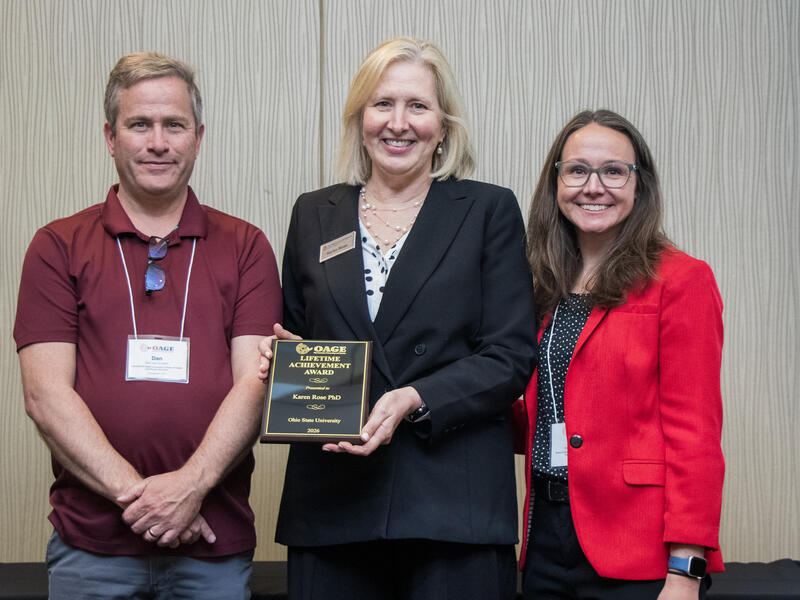 dean rose holds and displays her award plaque