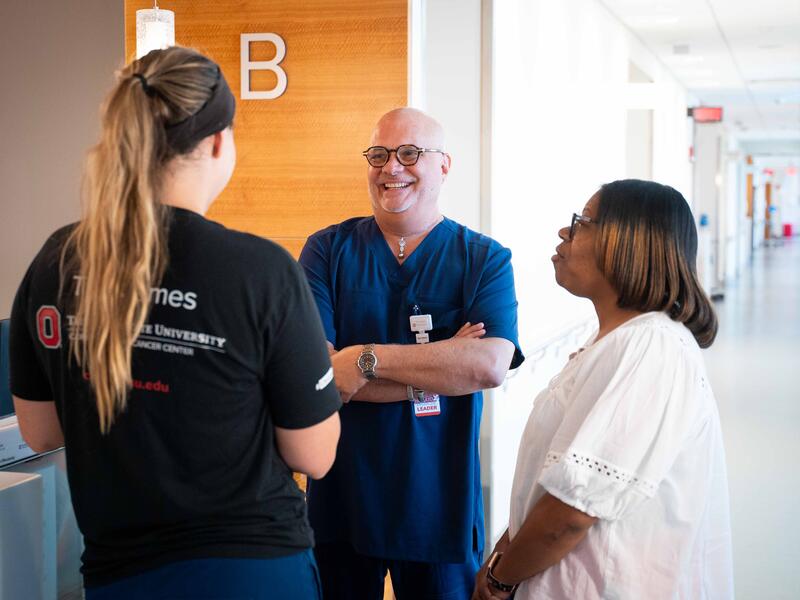 hospital staff, nurse leader and nurse talking in hallway