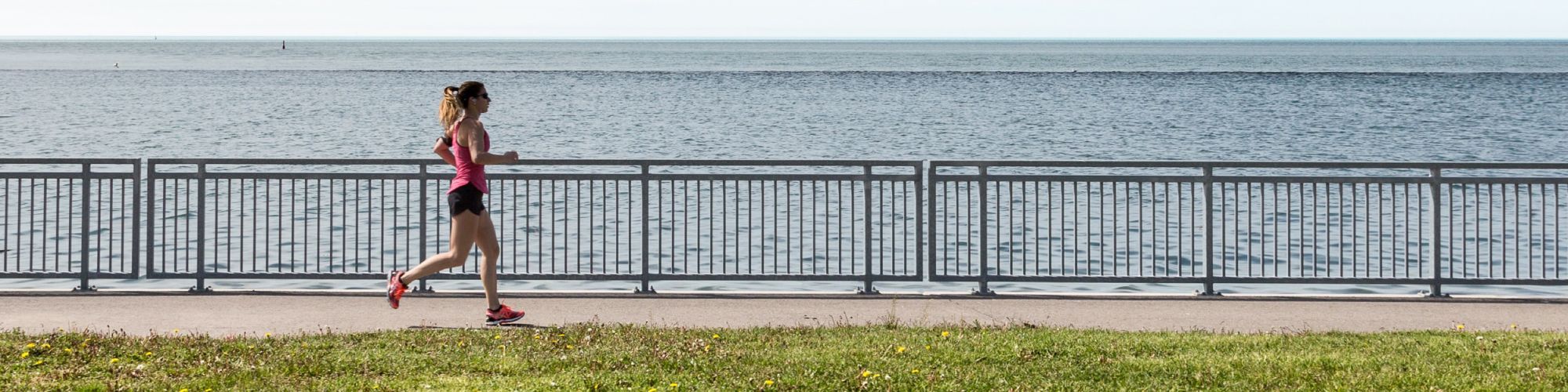 woman running on a path by a lake