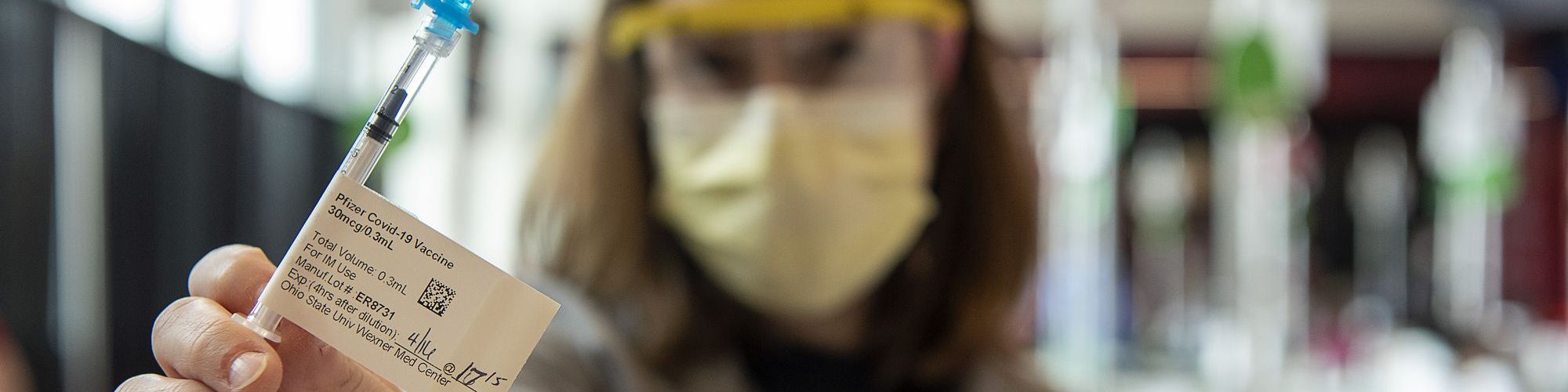 Healthcare provider holding up Pfizer COVID-19 vaccine