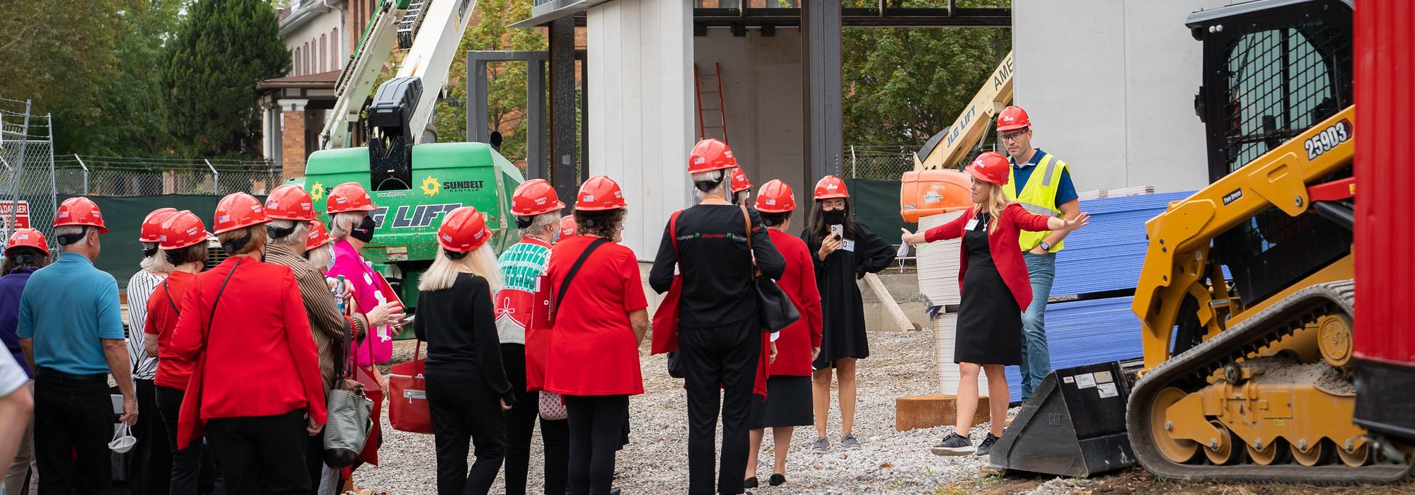 group of alumni touring the new building construction site during Homecoming weekend