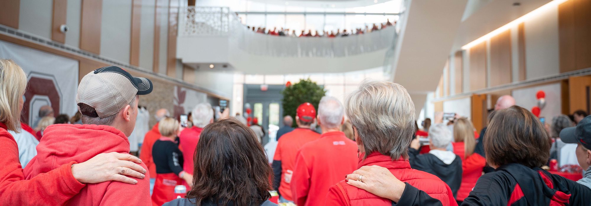 alumni and friends embrace in the atrium of Jane E. Heminger Hall at Homecoming