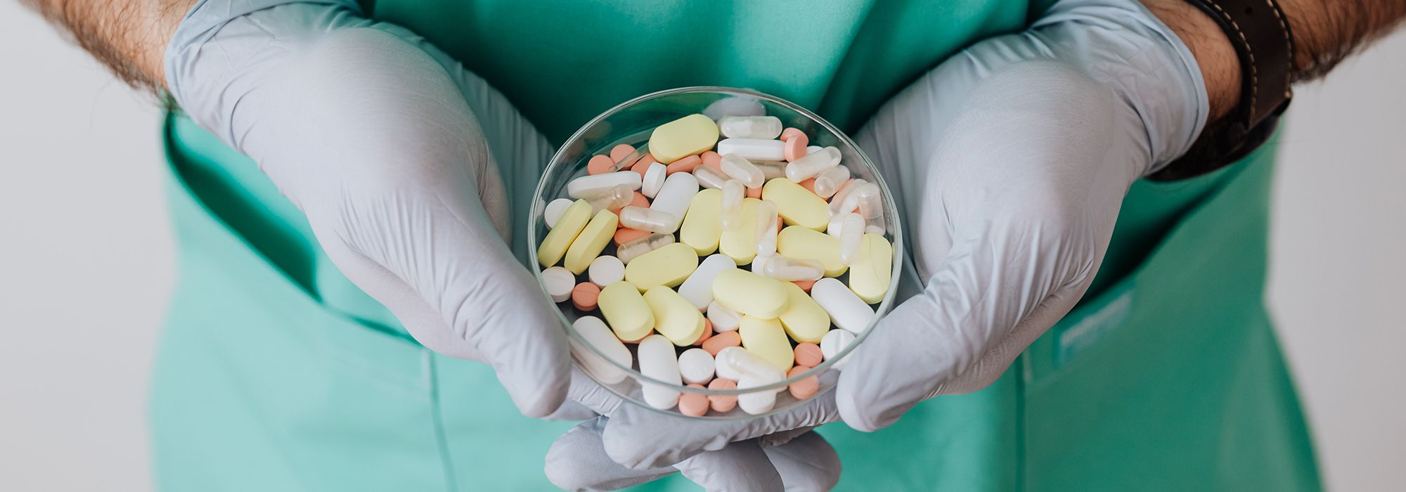 healthcare provider holding petri dish full of medications