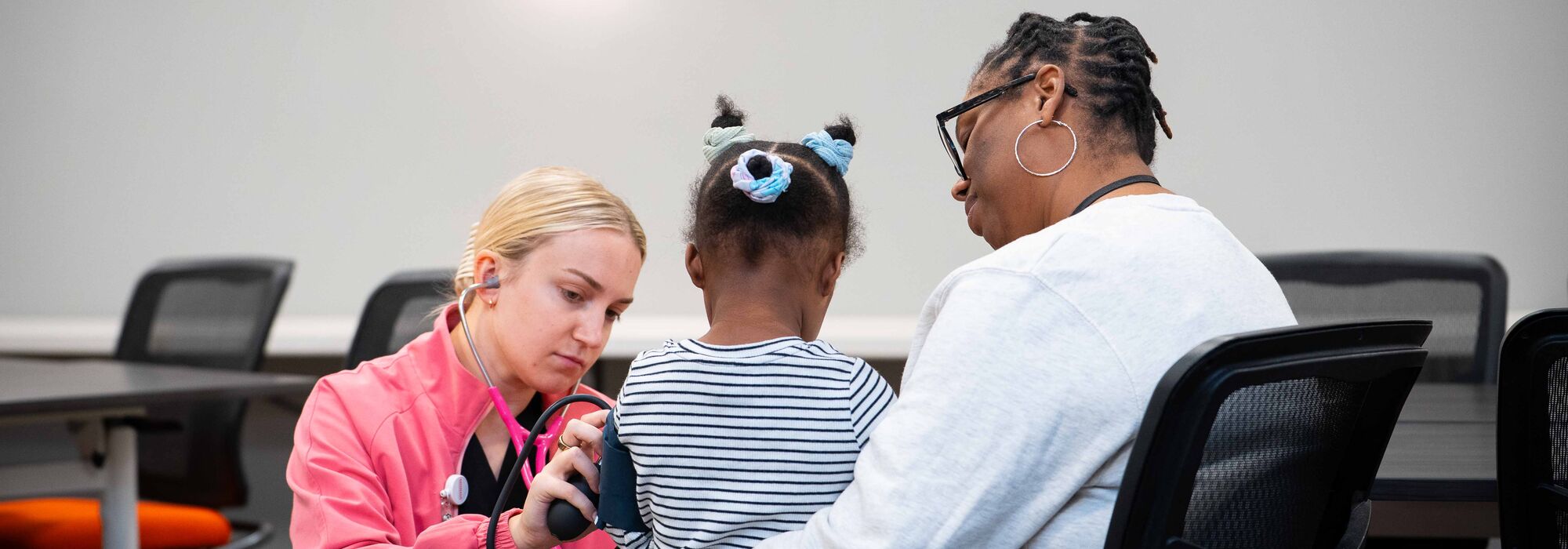 FNP student Alison Benner takes a child's blood pressure.
