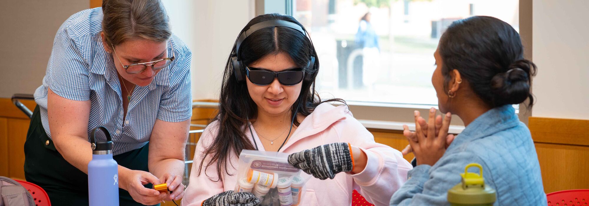 Morgan Angles (left) assists students in the simulation.